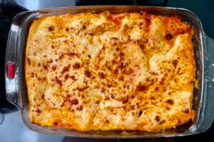 A glass baking dish filled with Easy Venezuelan Pasticho, topped with a golden-brown, slightly crispy cheese layer.