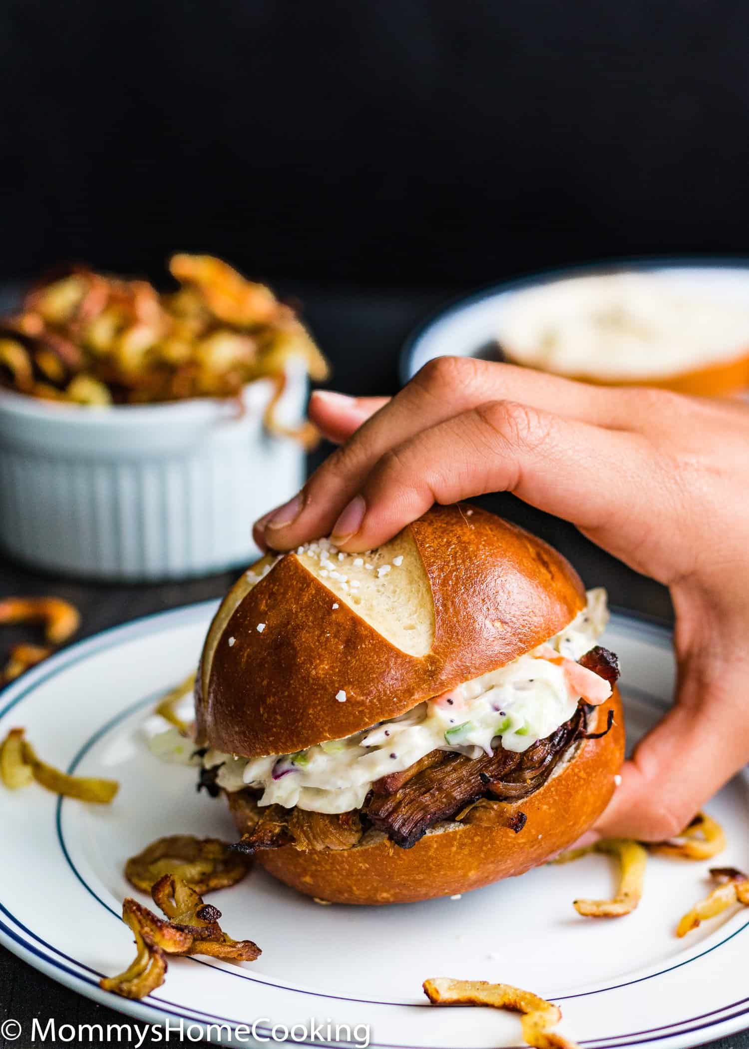a hand holding a Cranberry barbecue Pulled Pork sandwich.