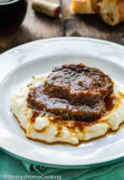 Venezuelan Asado Negro in a white plate with mashed potatoes