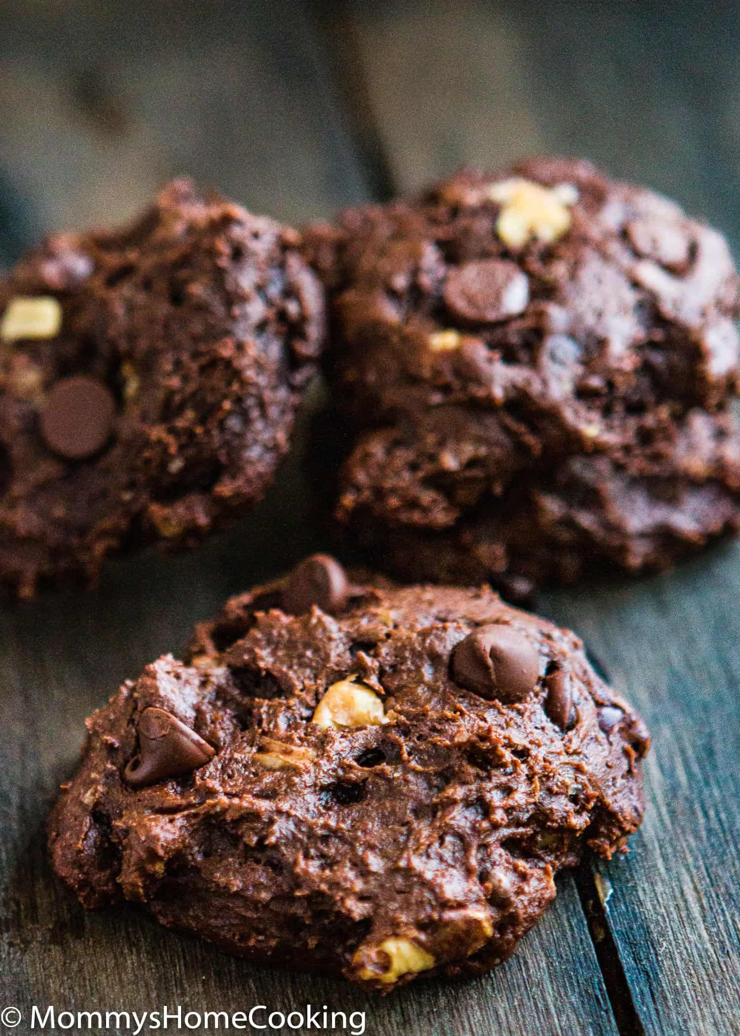 closeup view of three healthy double chocolate cookies over a wooden surface
