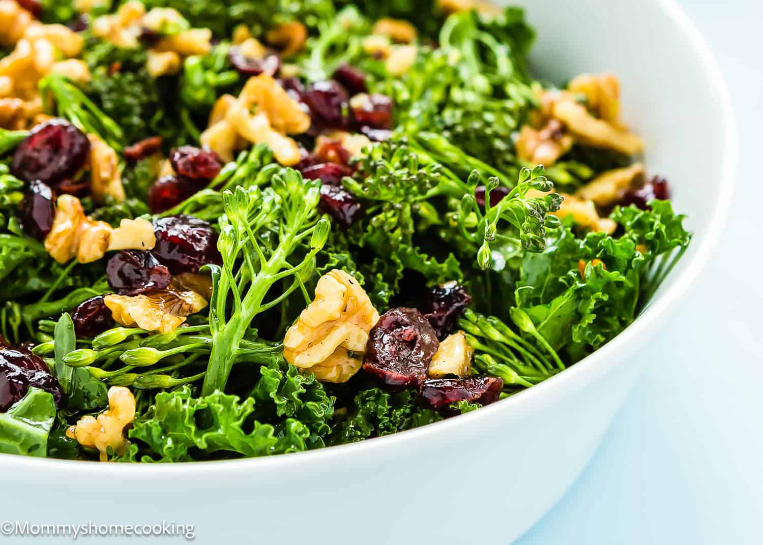 A bowl of Chick fil A Kale Salad with walnuts and dried cranberries.