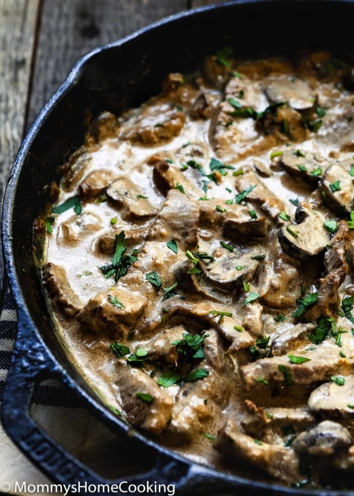 A skillet brimming with Easy Beef Stroganoff, showcasing sliced beef and mushrooms bathed in a creamy sauce, all garnished with chopped parsley.