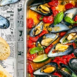 baked mussel with tomatoes, and cappers in a baking pan
