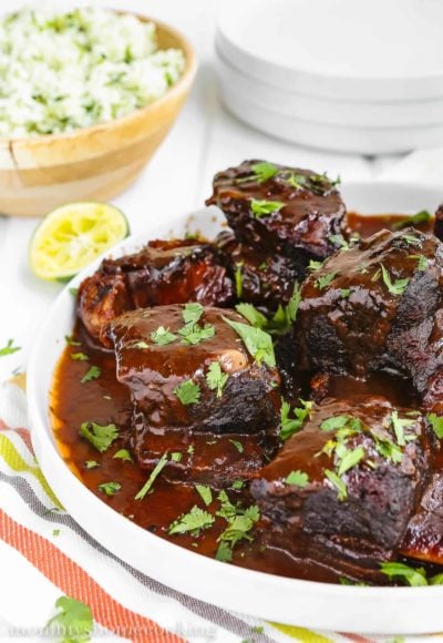 mexican short ribs with sauce in a serving plate
