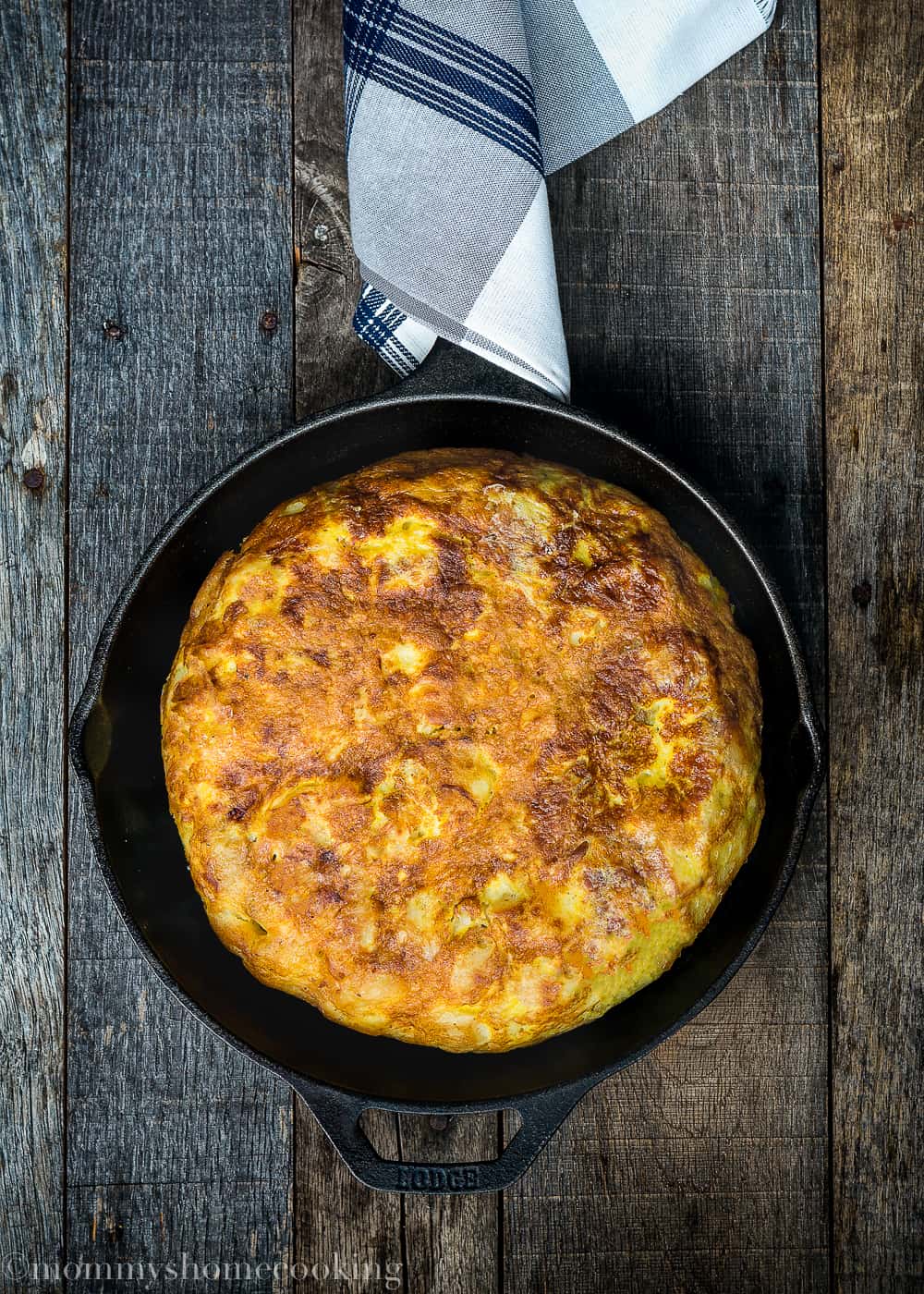 Tortilla Española in a skillet over a wooden surface
