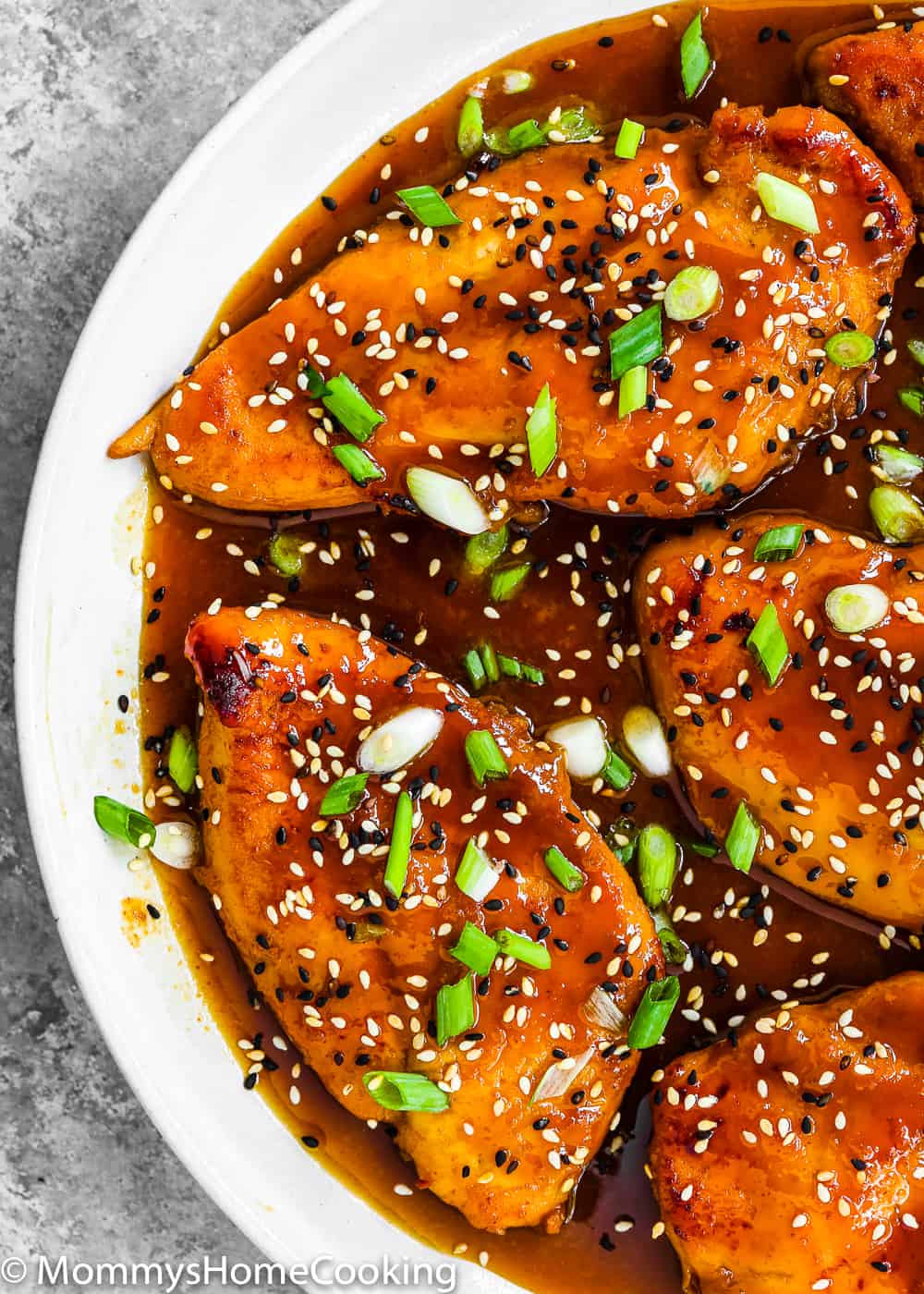 Easy Asian-Style Chicken Breasts in a white skillet  sprinkled with sesame seeds