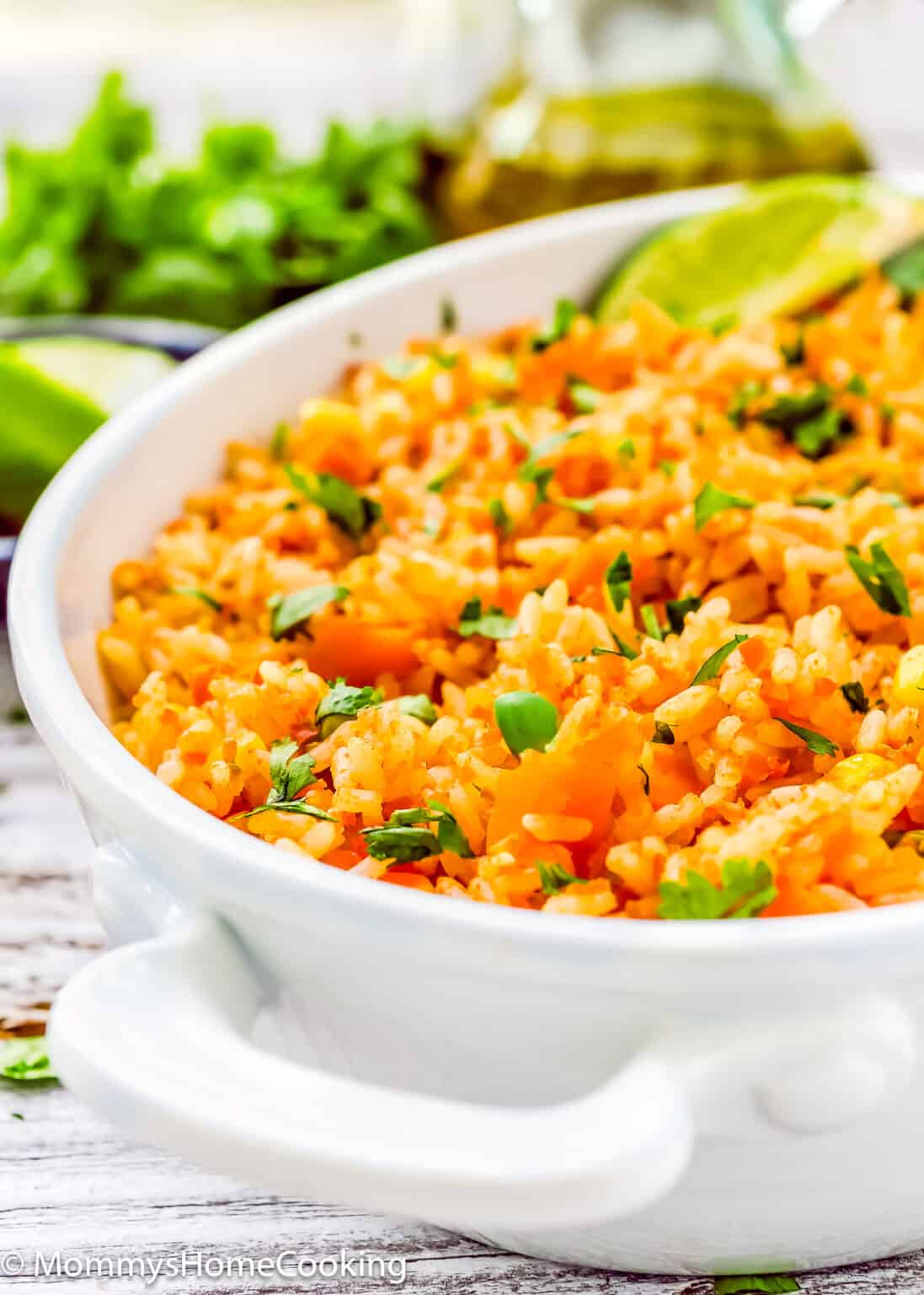 Easy Mexican rice in a serving bowl garnished with cilantro and lime juice.