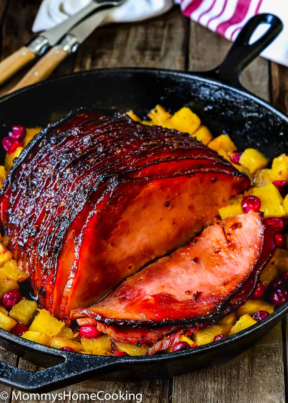 Chipotle Glazed Ham in a cast iron skillet with pineapple and cranberries