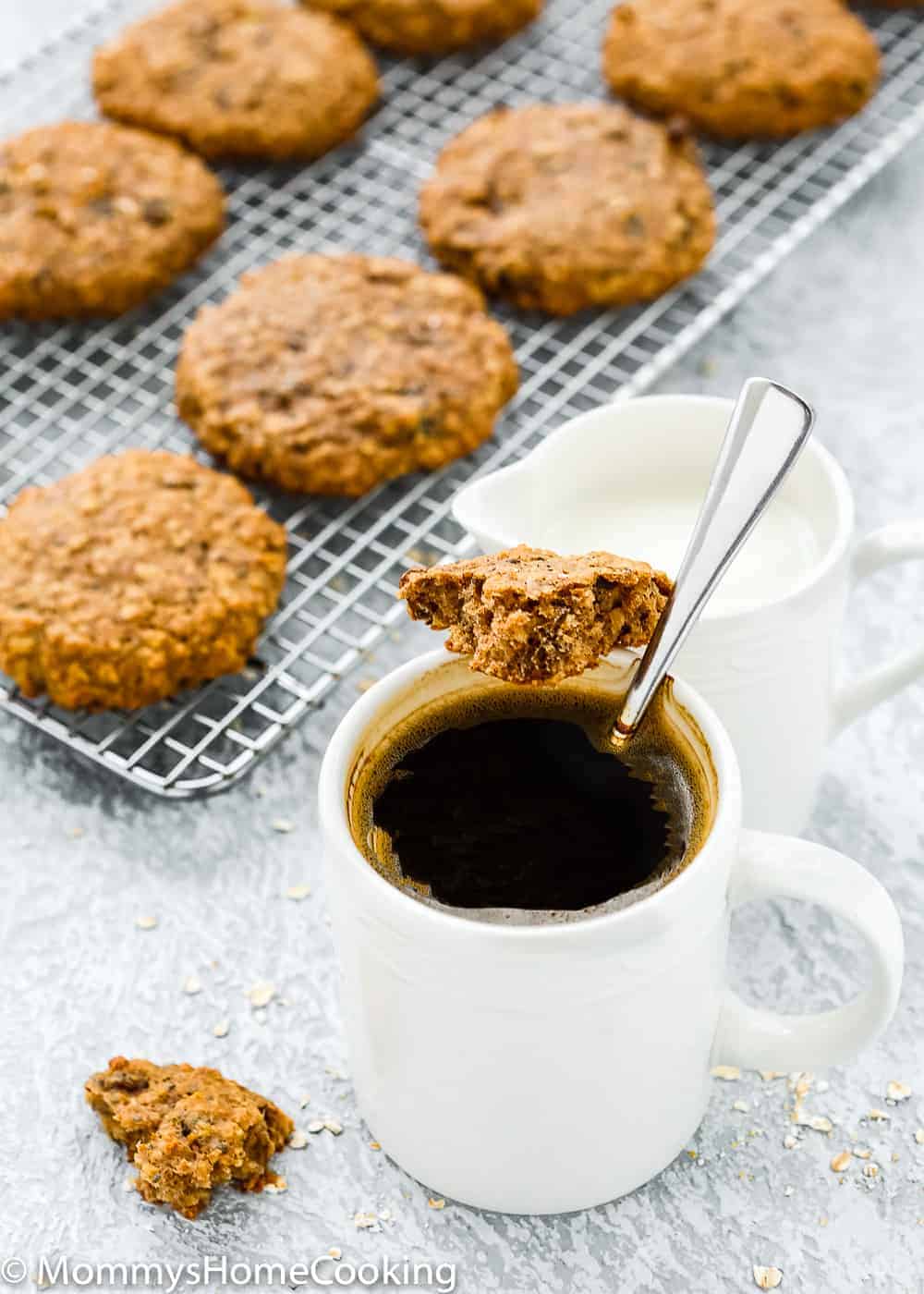 eggless breakfast cookies in a cooling rack with a cup of coffee and milk