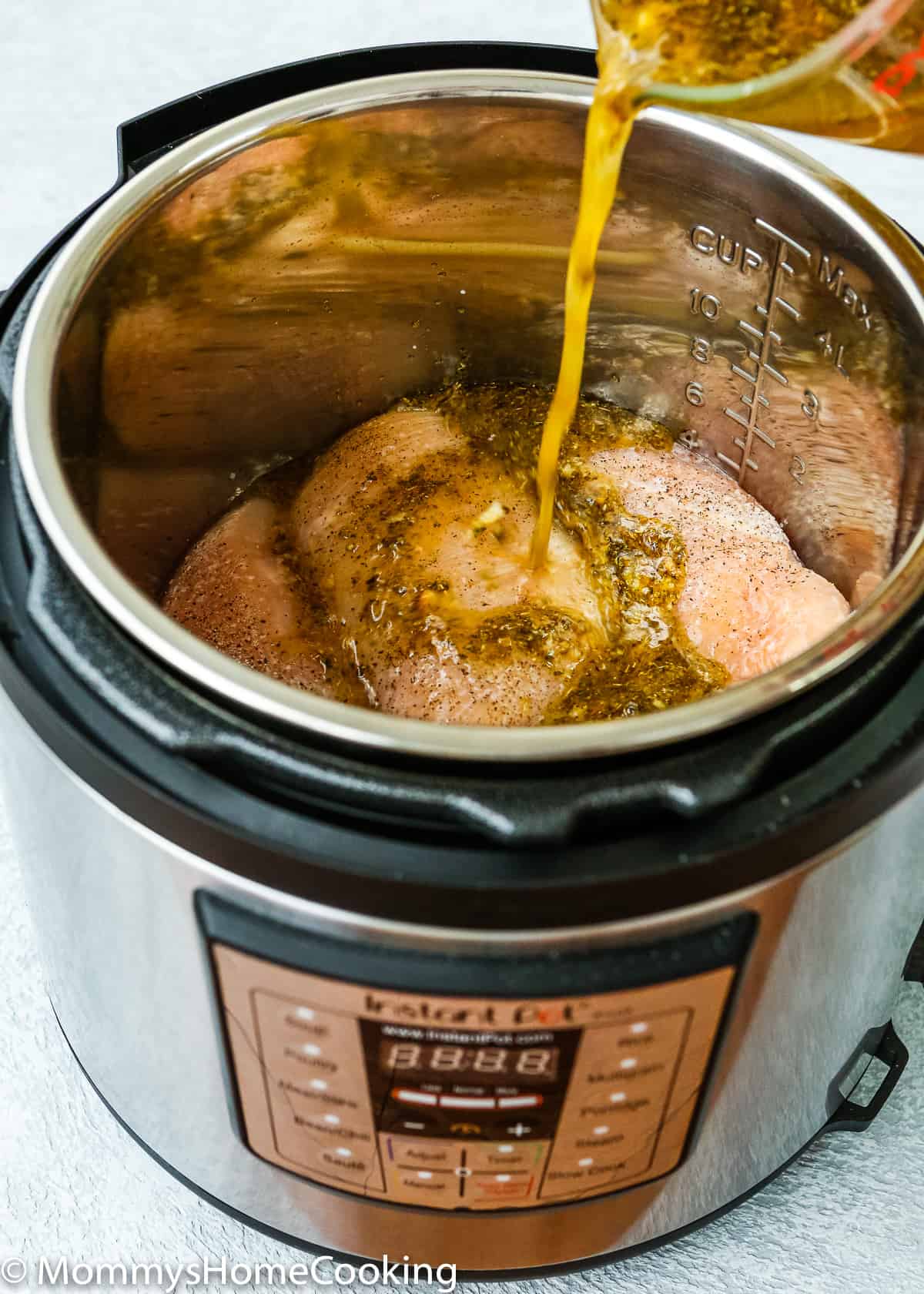 chicken breasts in a pressure cooker pot with mojo sauce