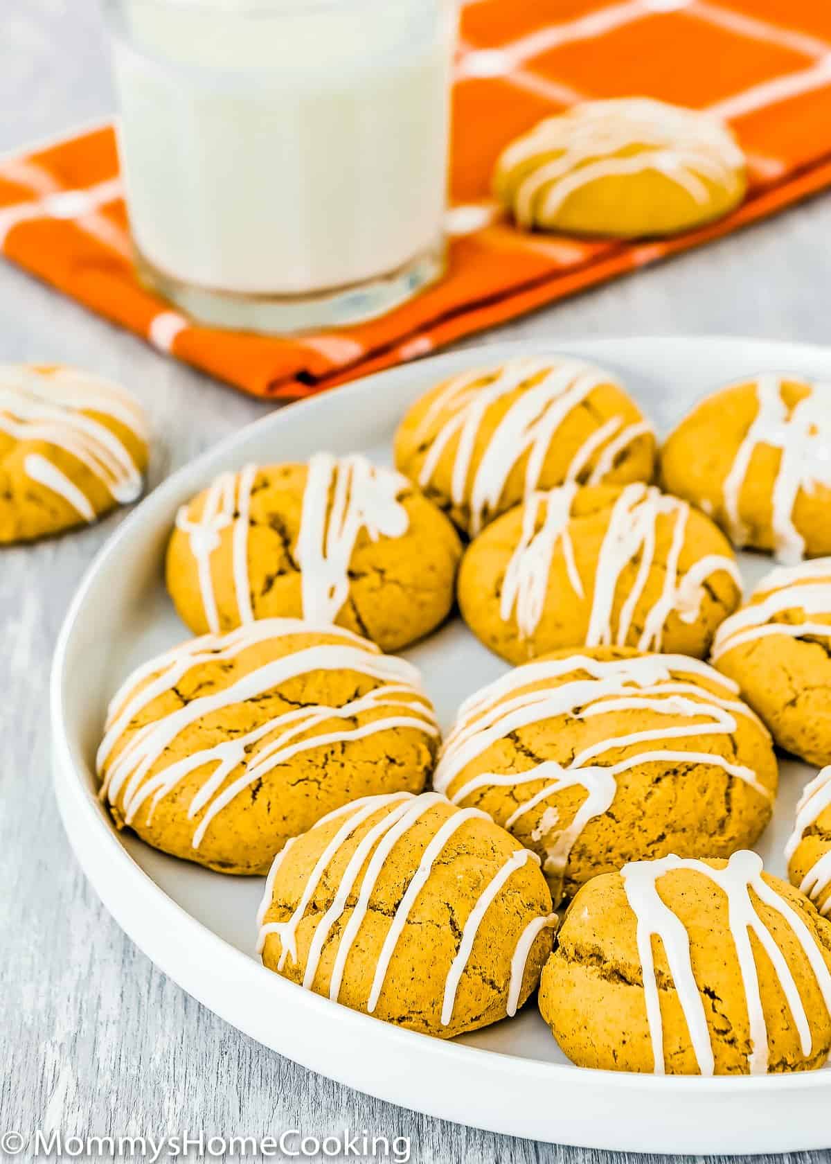Eggless Pumpkin Cookies on a plate with a glass of milk on the background.