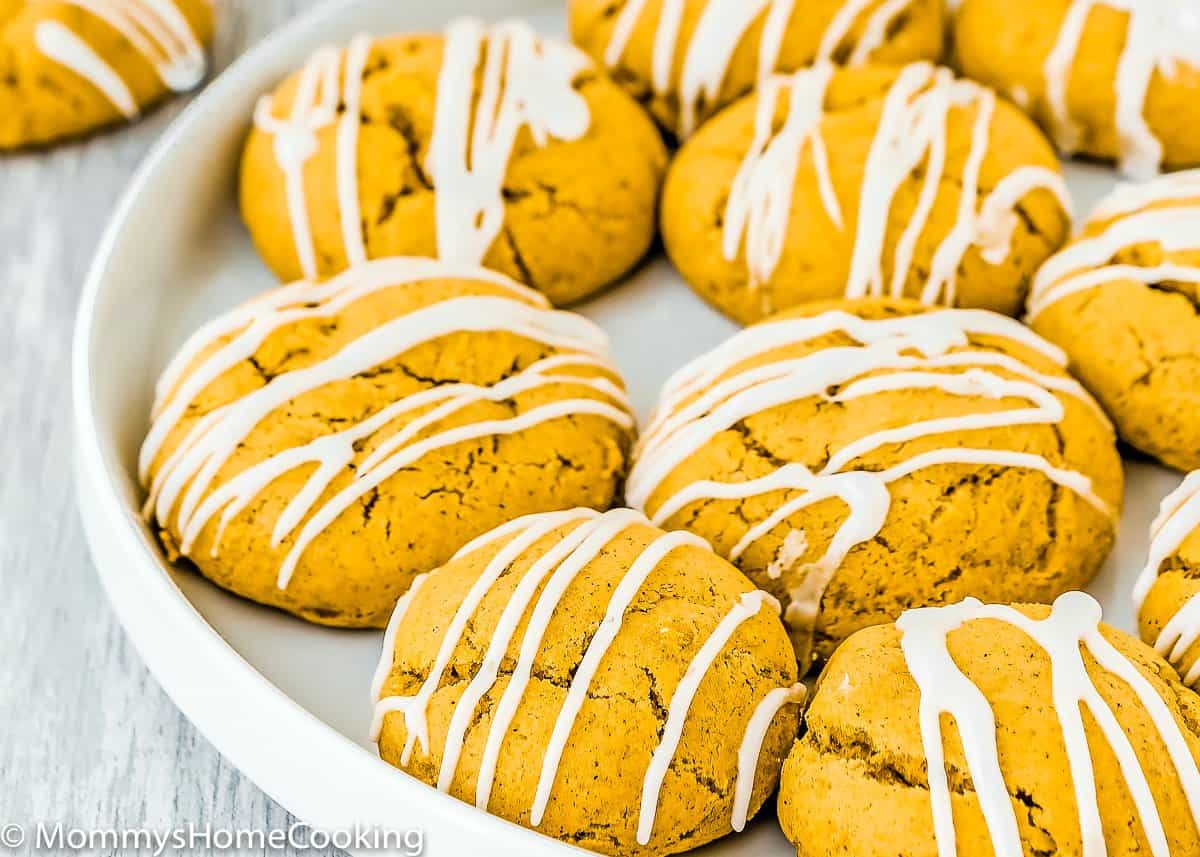 Soft Eggless Pumpkin Cookies with sugar glaze on a white plate.