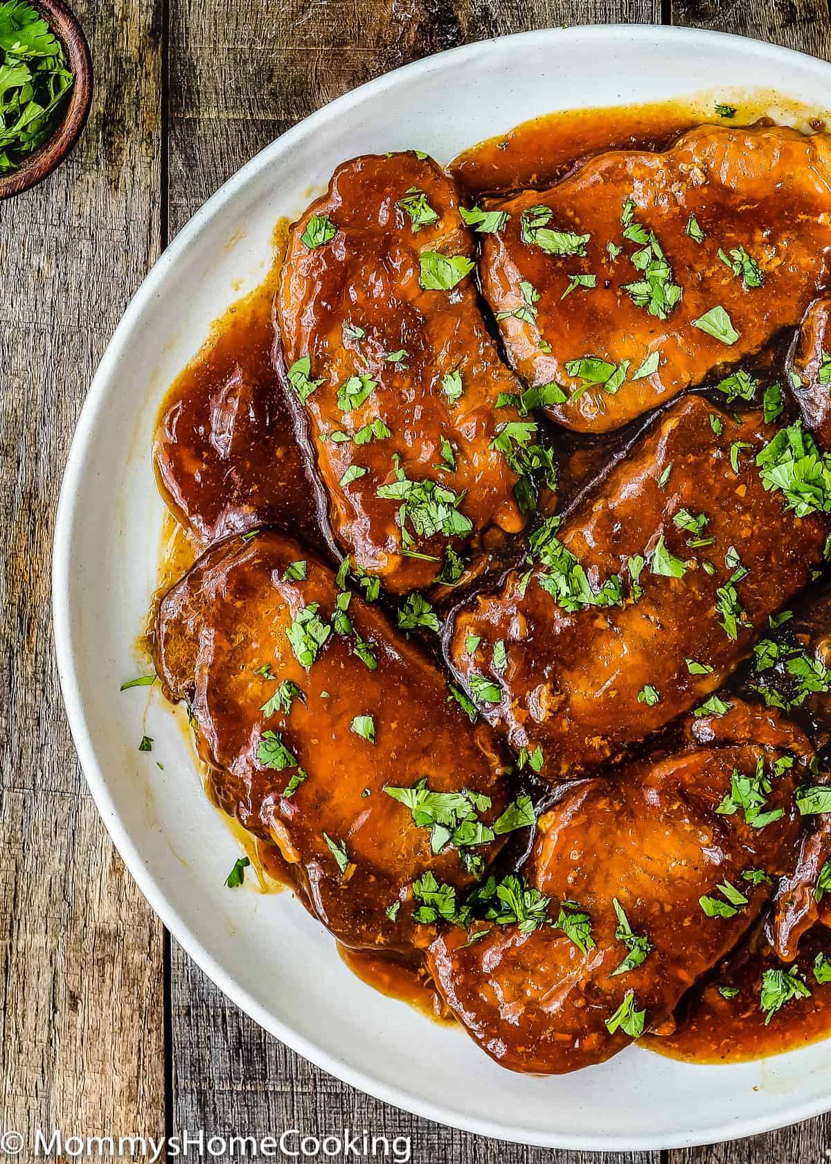 visão aérea de costeletas de porco Honey Garlic em um prato guarnecido com salsa.