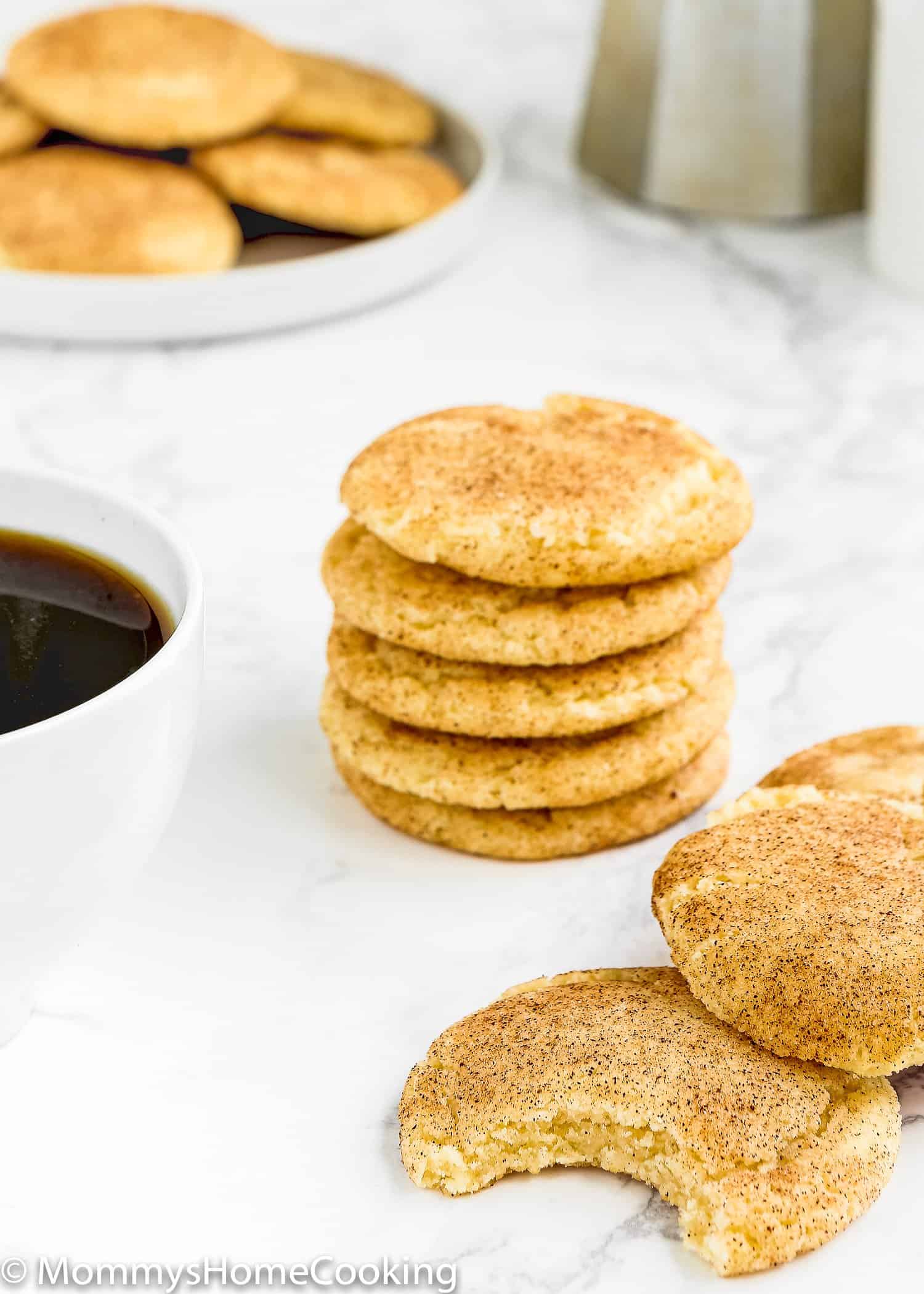 Eggless Snickerdoodle Cookies over a marble surface with a cup of coffee on the side