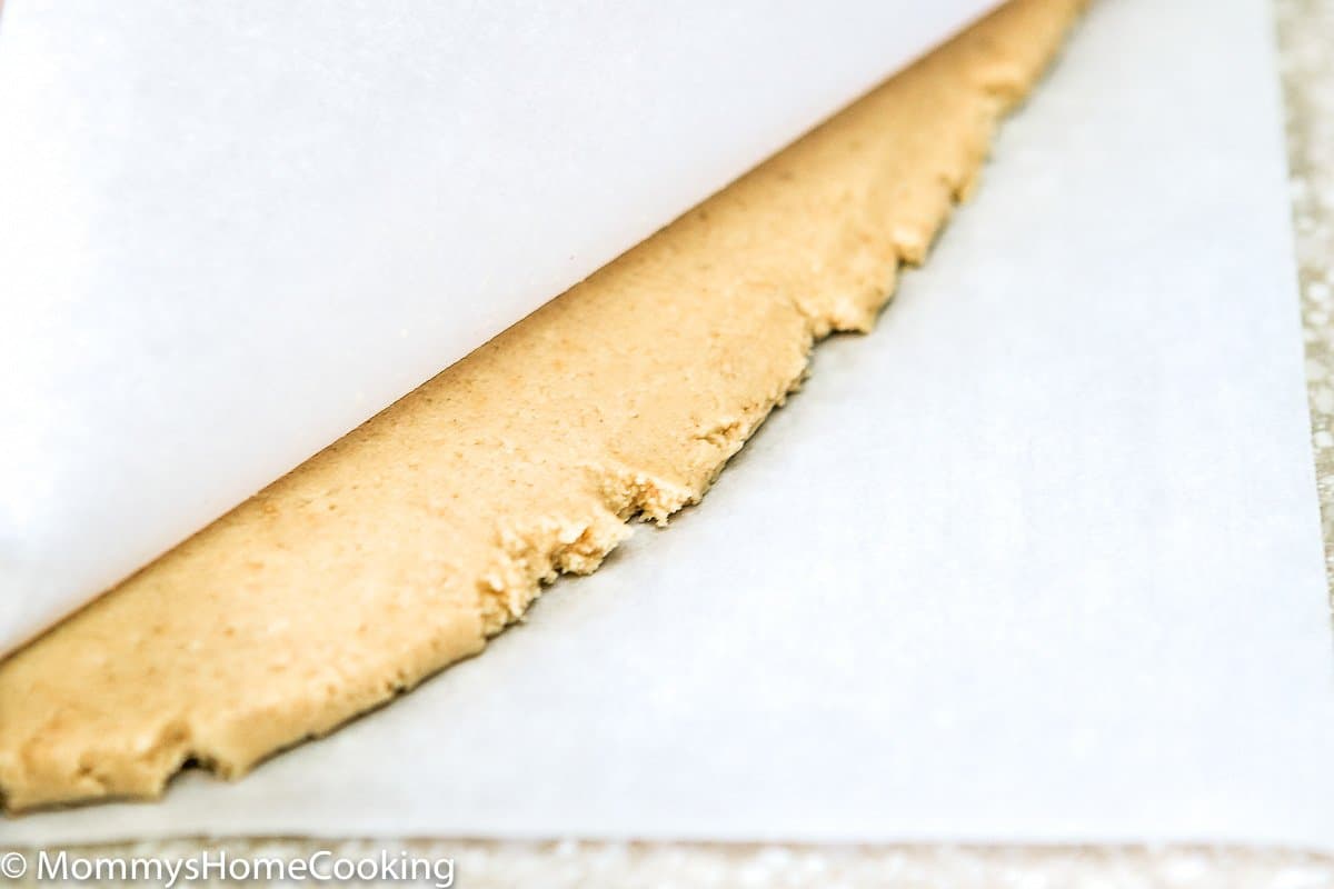 egg-free sugar cookie dough between two pieces of parchment paper