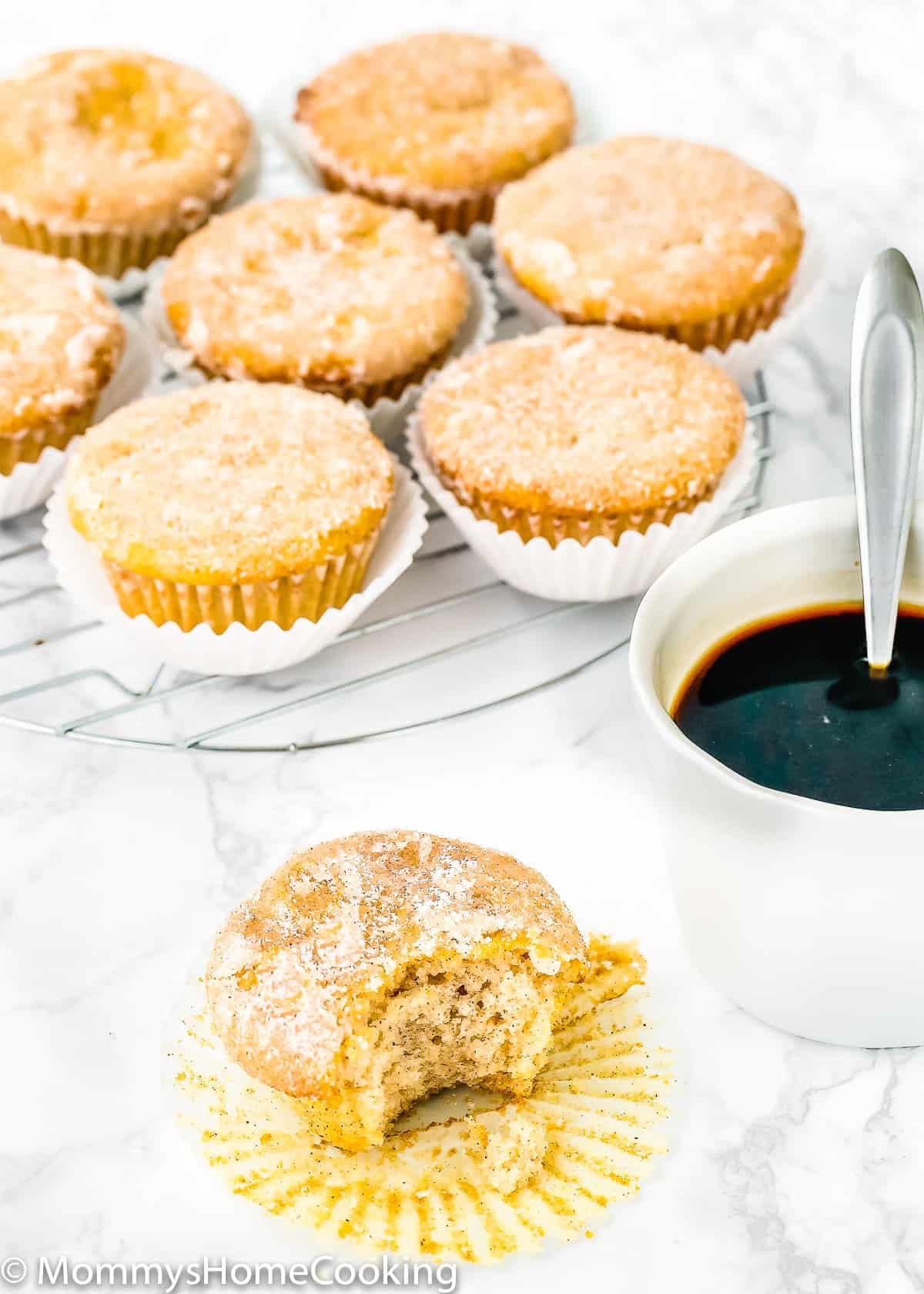 Eggless Sugar Donut Muffins over a cooling rack and a cup of coffee with a spoon