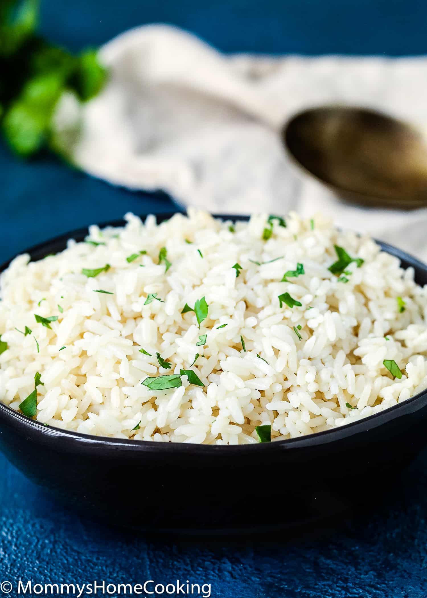 Fluffy Rice that has been made in the Instant Pot in a serving bowl with chopped parsley on top. 