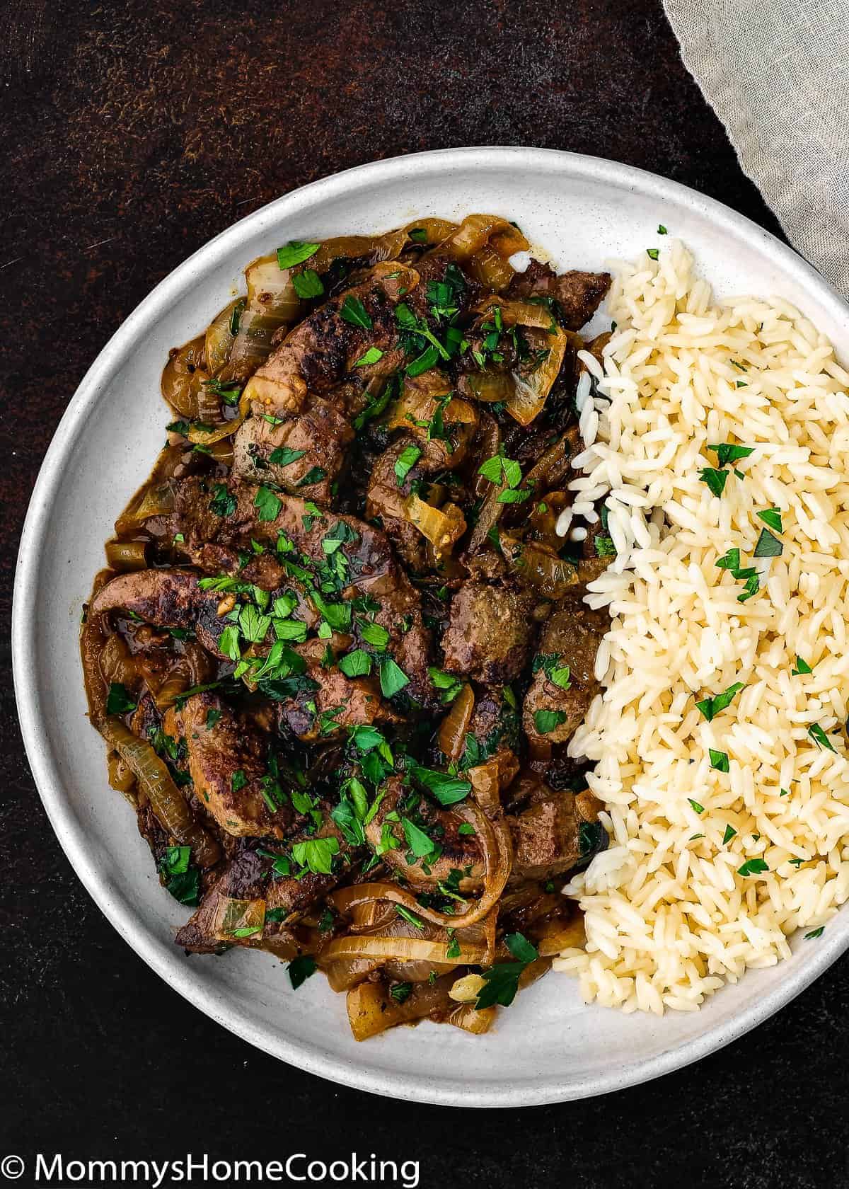 overhead view of liver and onion with white rice in a plate