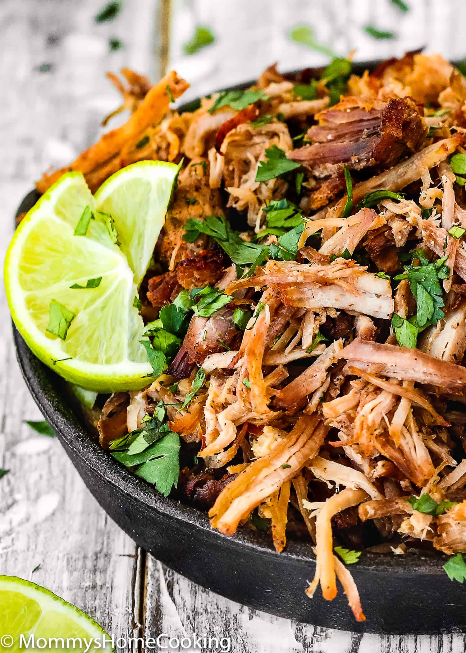 crispy pork carnitas with lemon wedges on the side.