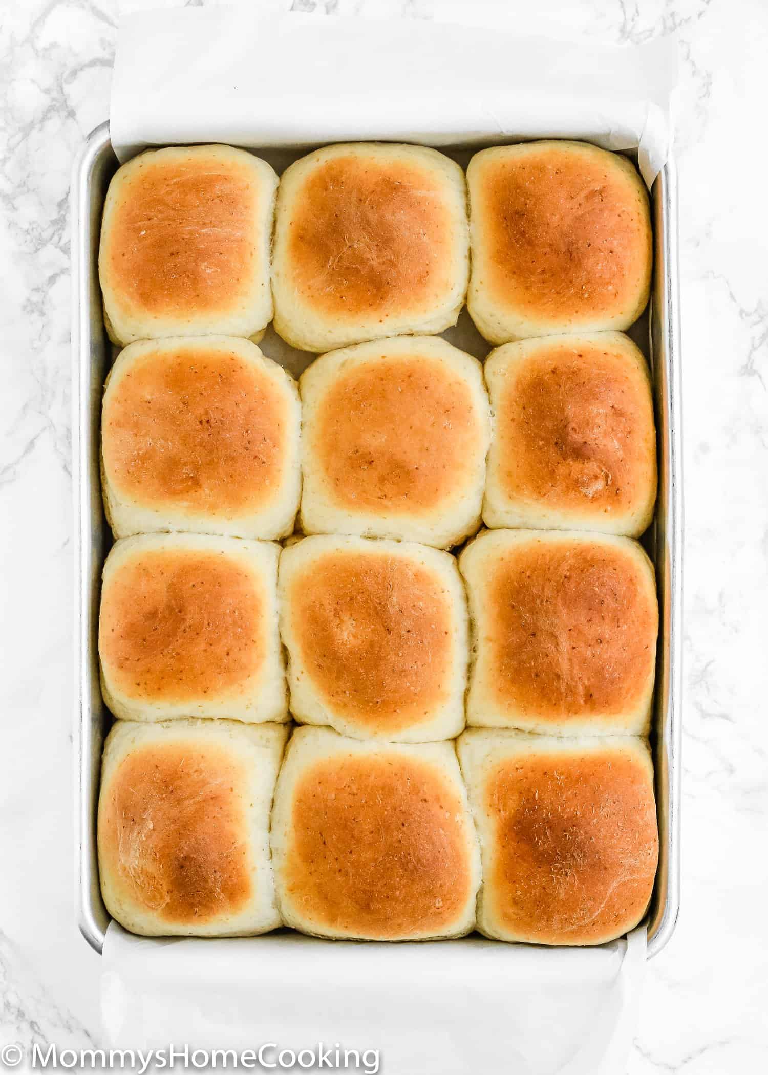 A pan of freshly baked dinner rolls made without egg.
