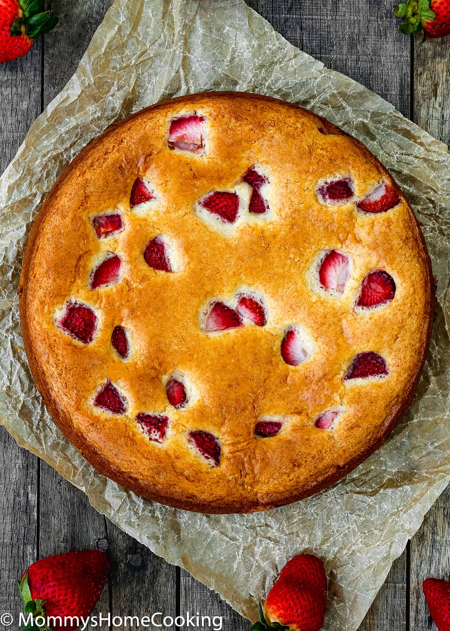 a whole eggless strawberry cake with strawberry pieces in it. 