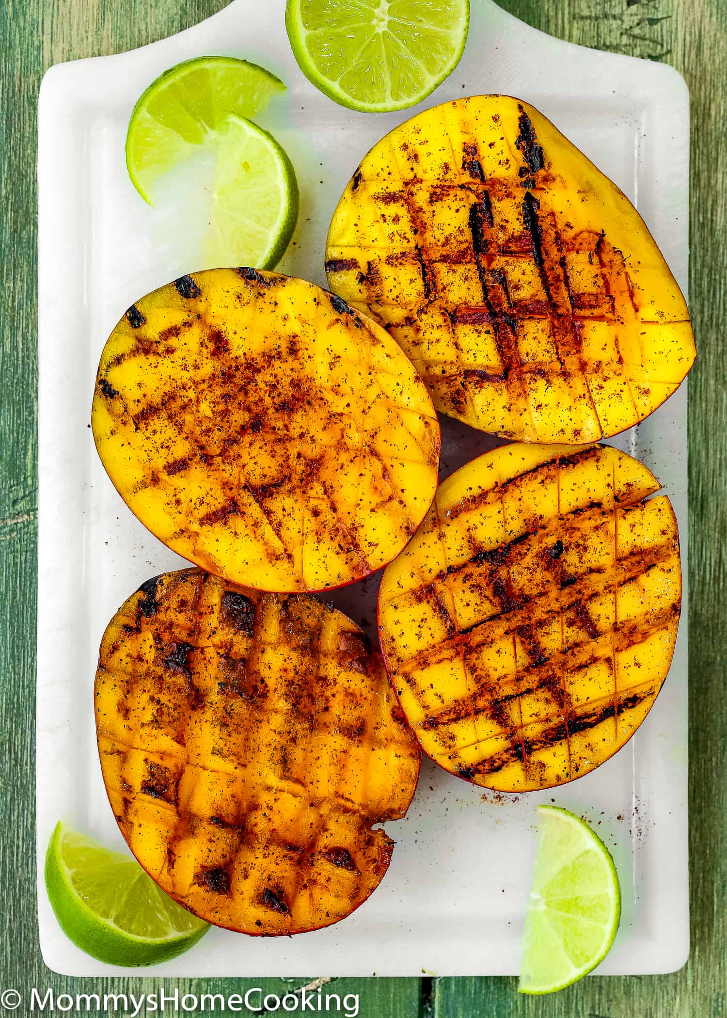 grilled mangoes on a cutting board.