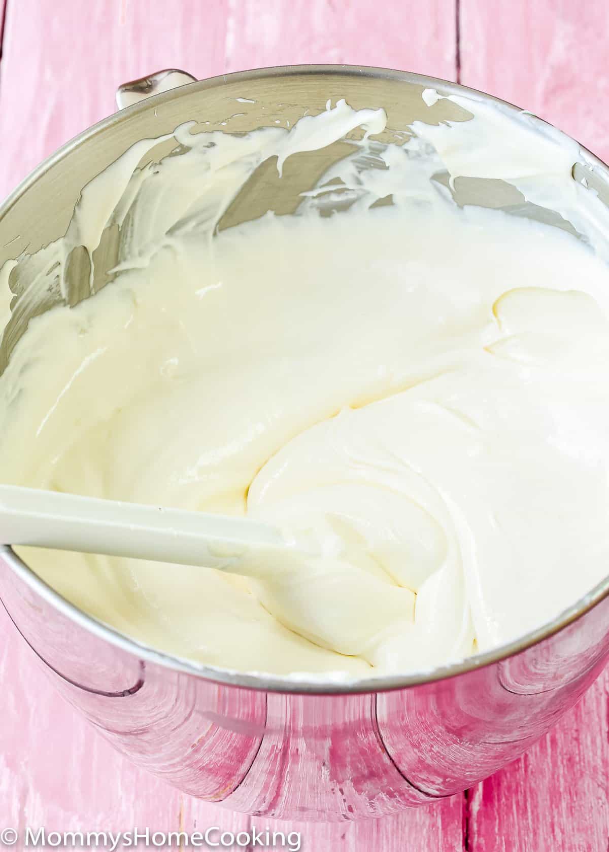 eggless cheesecake batter in a mixing bowl with a spatula