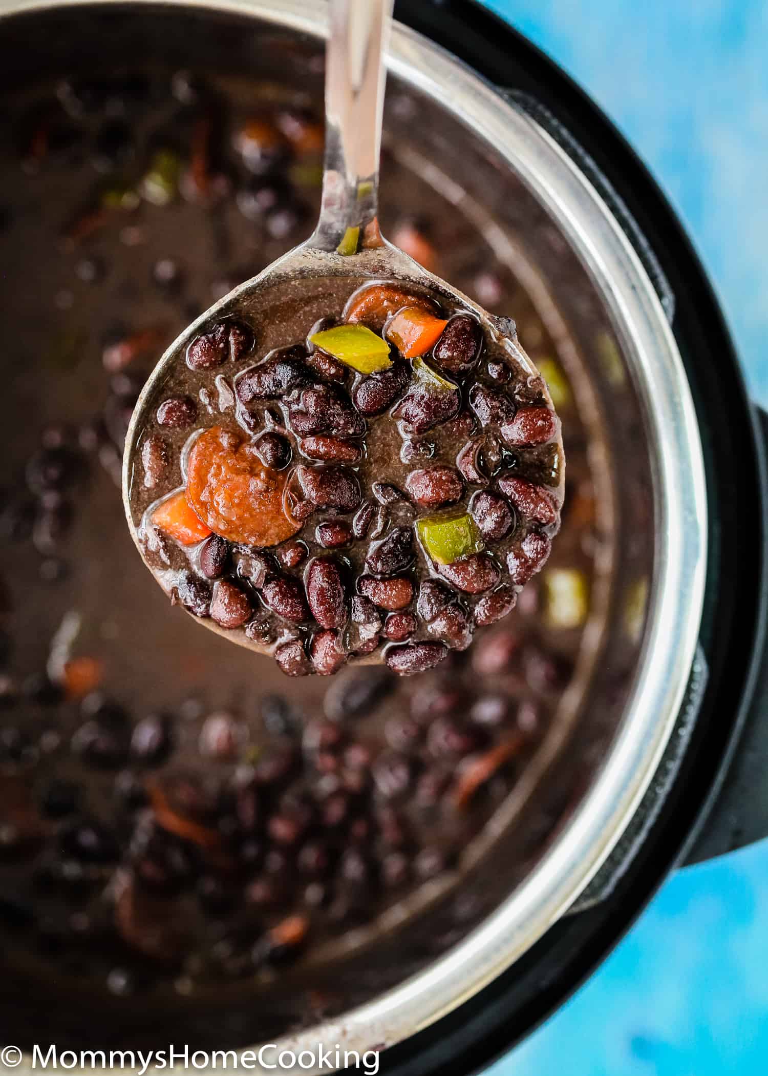 a soup ladle with three easy venezuelan black bean soup.