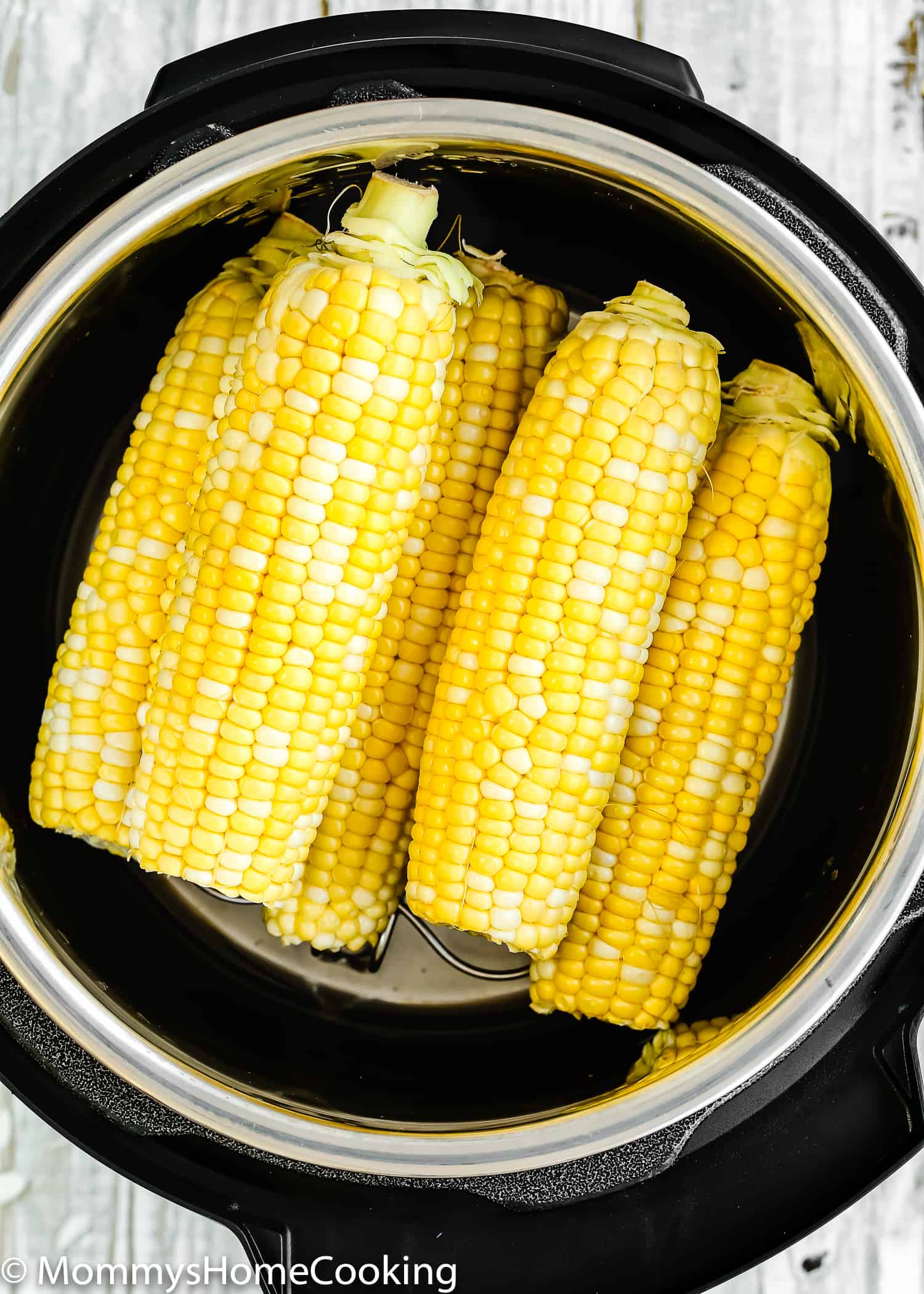fresh corns on the cob into a pressure cooker.