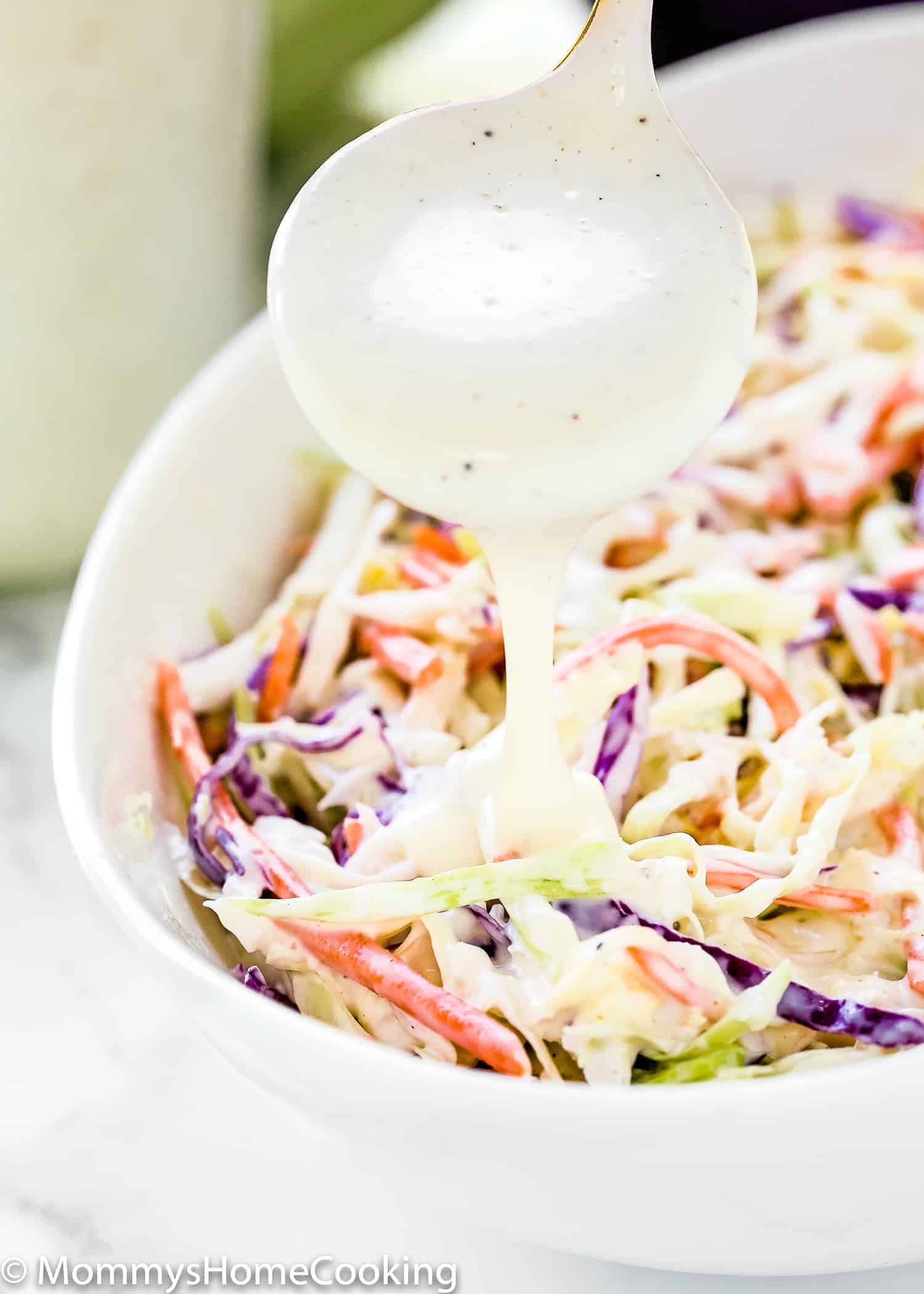 dressing being poured over coleslaw. 