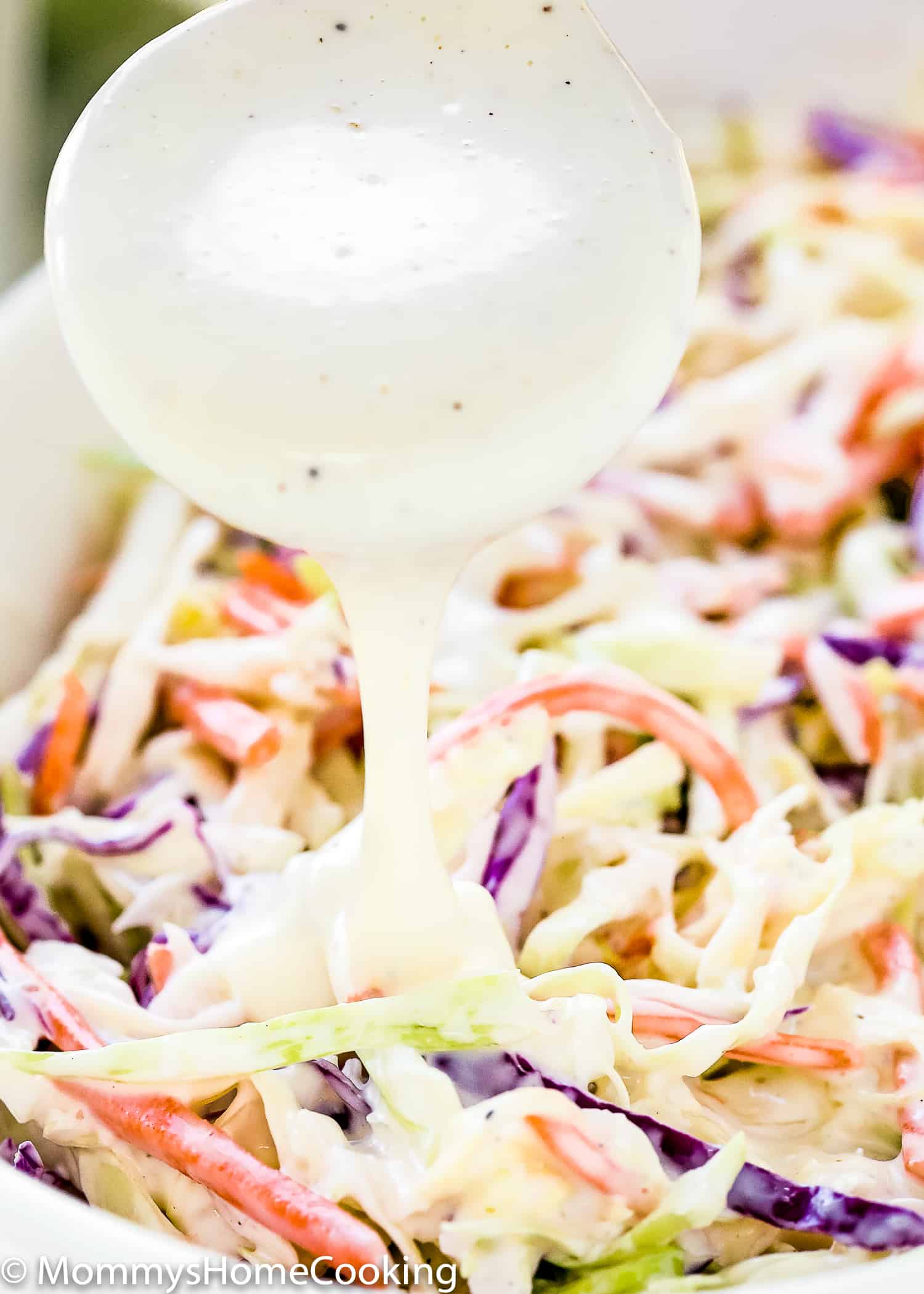 dressing being poured over coleslaw. 