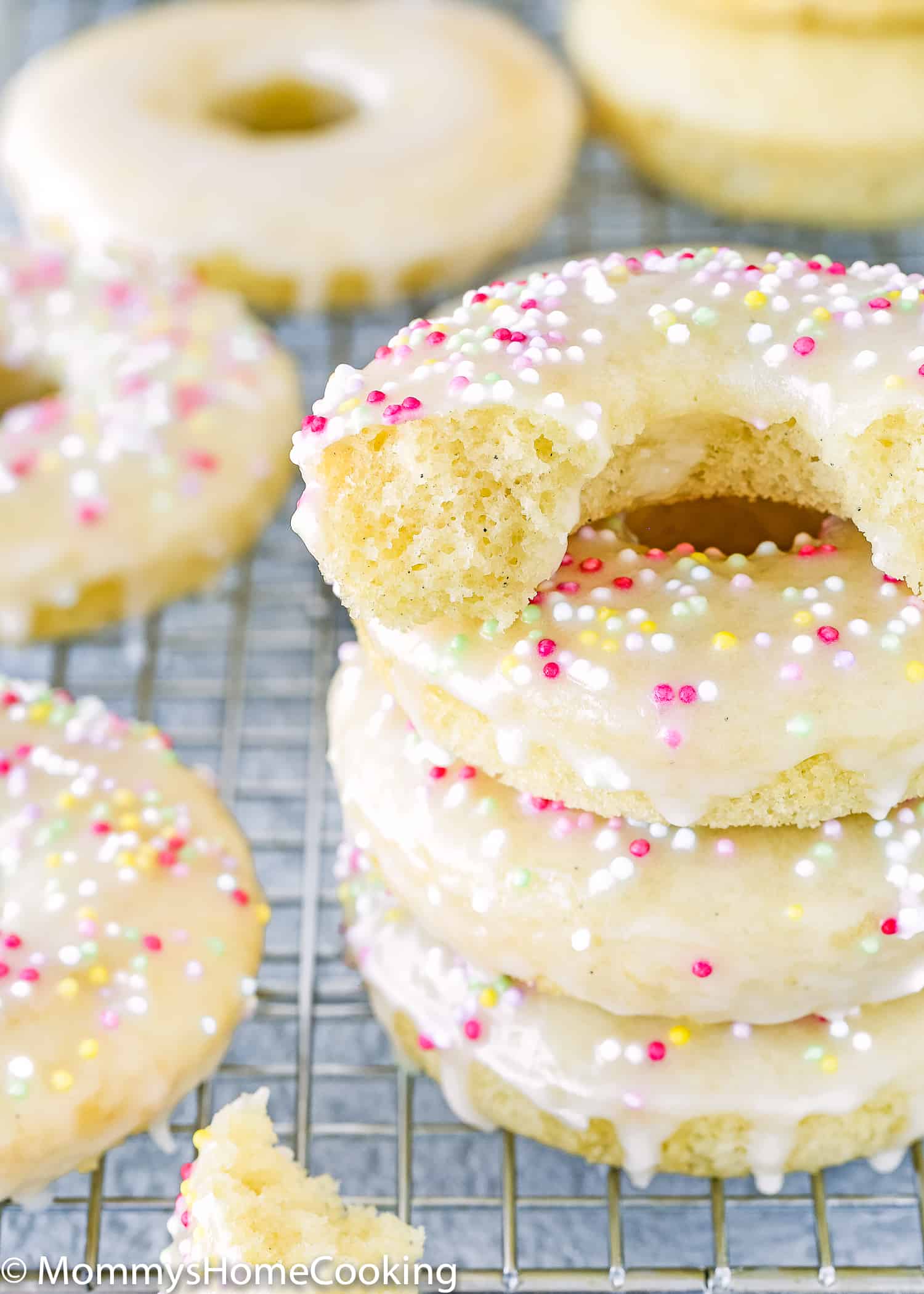 A stack of three eggless donuts with one on top that's cut in half, showing the fluffy interior.