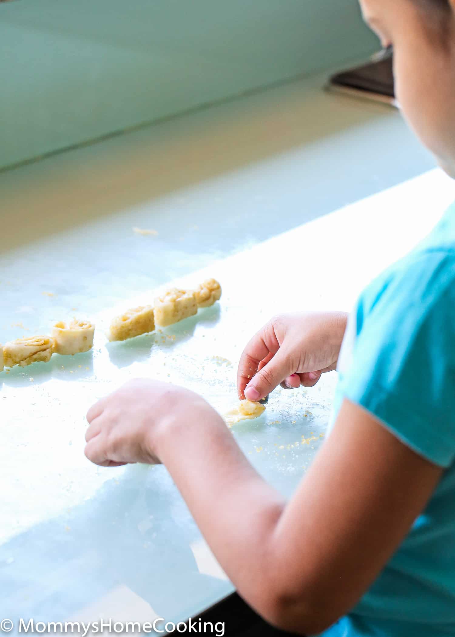 a little girl rolling palmiers cookies. 