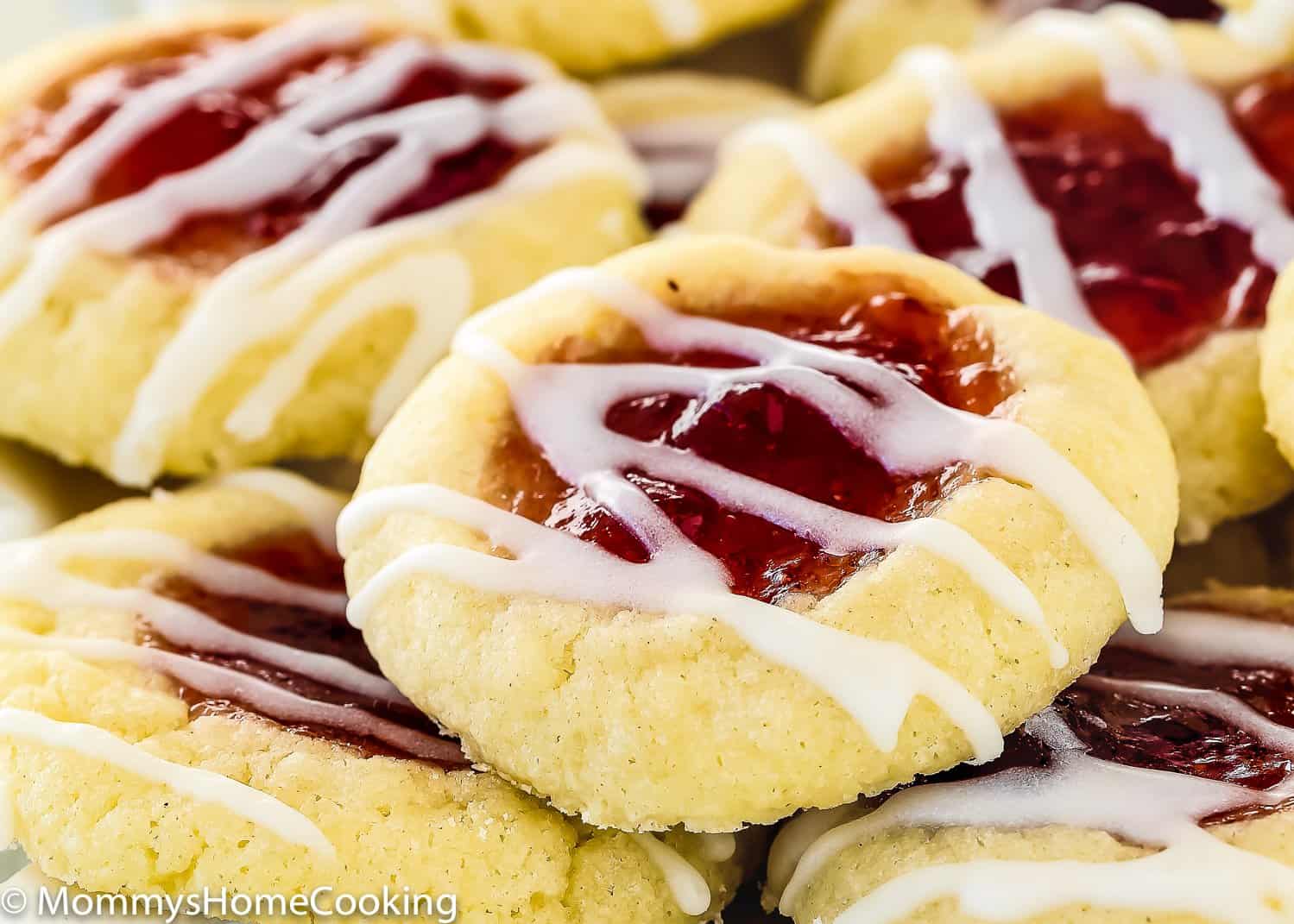 close up view of a egg-free thumbprint cookie with jam and glaze
