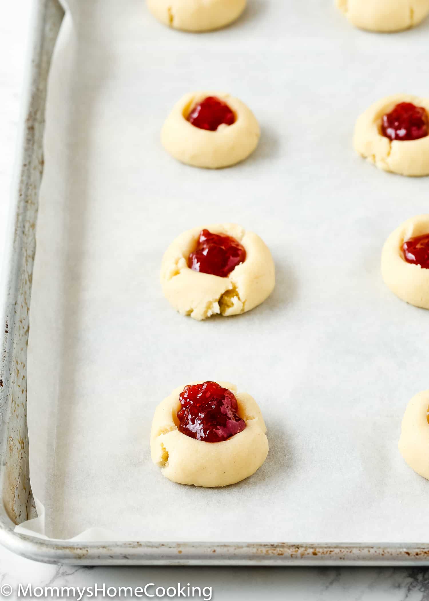 closeup view of a egg-free thumbprint cookie with strawberry jam.