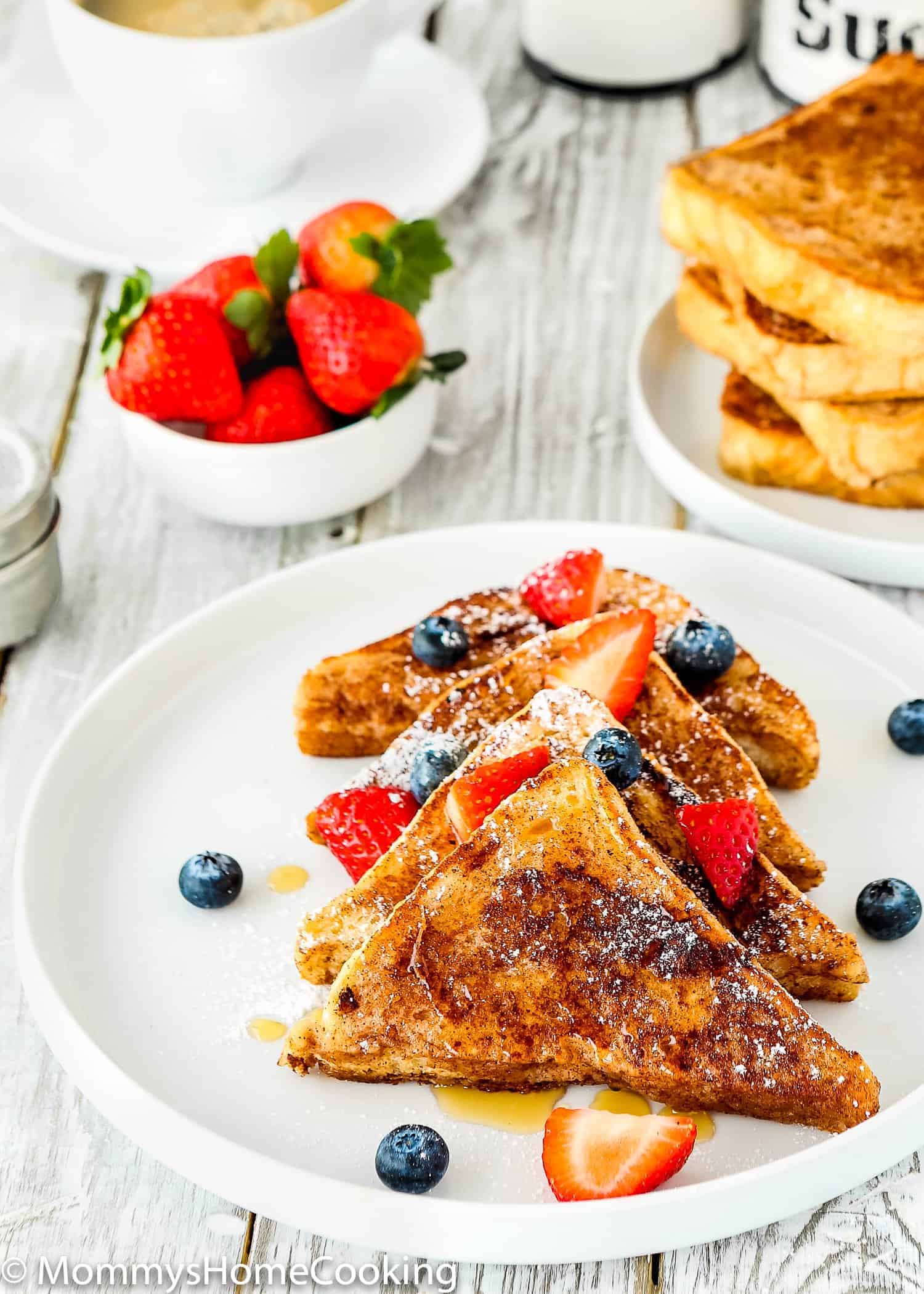 A plate of French toast that was made without eggs with fresh fruit on top.