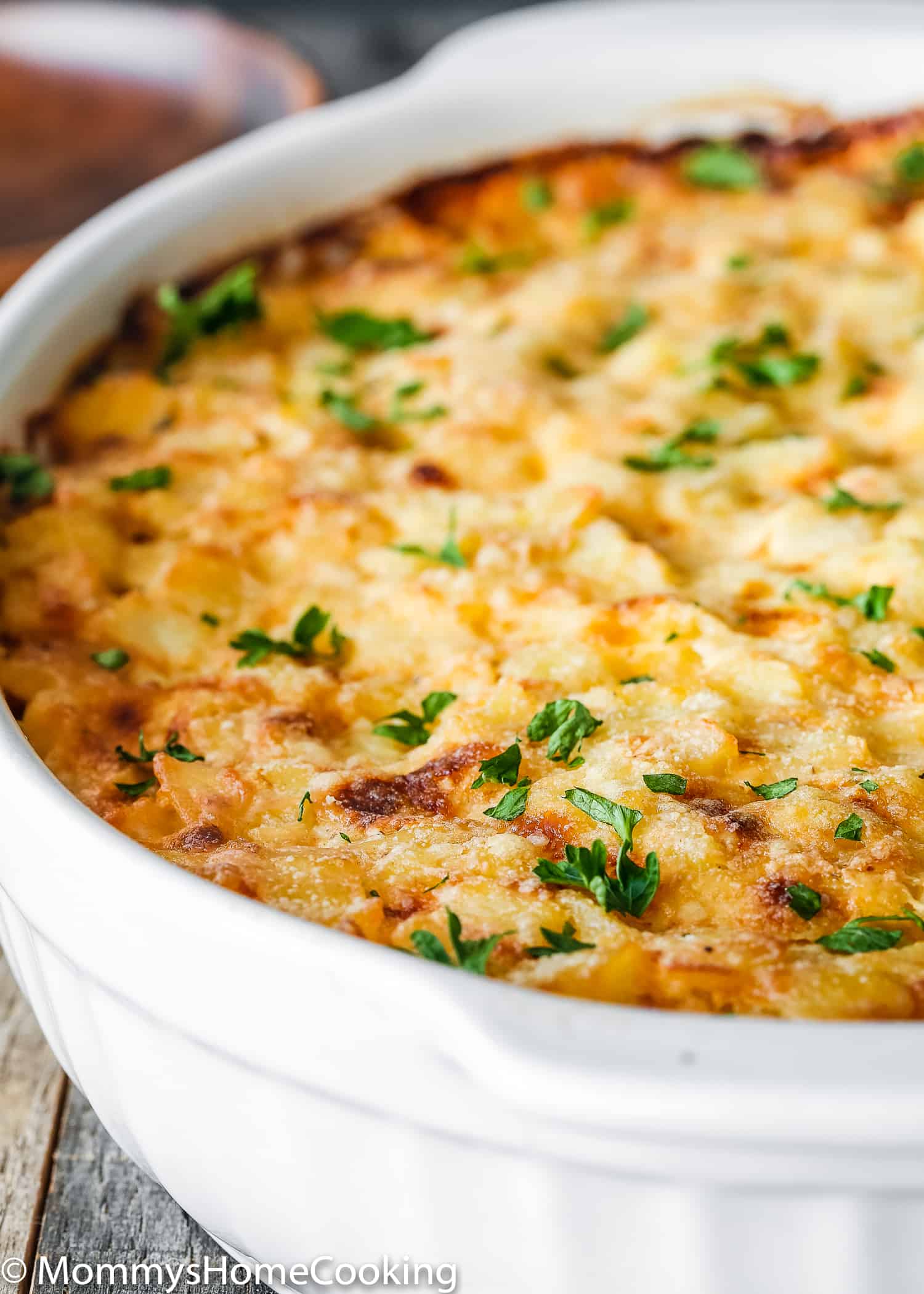Cheesy Hash Browns Casserole over a wooden surface.