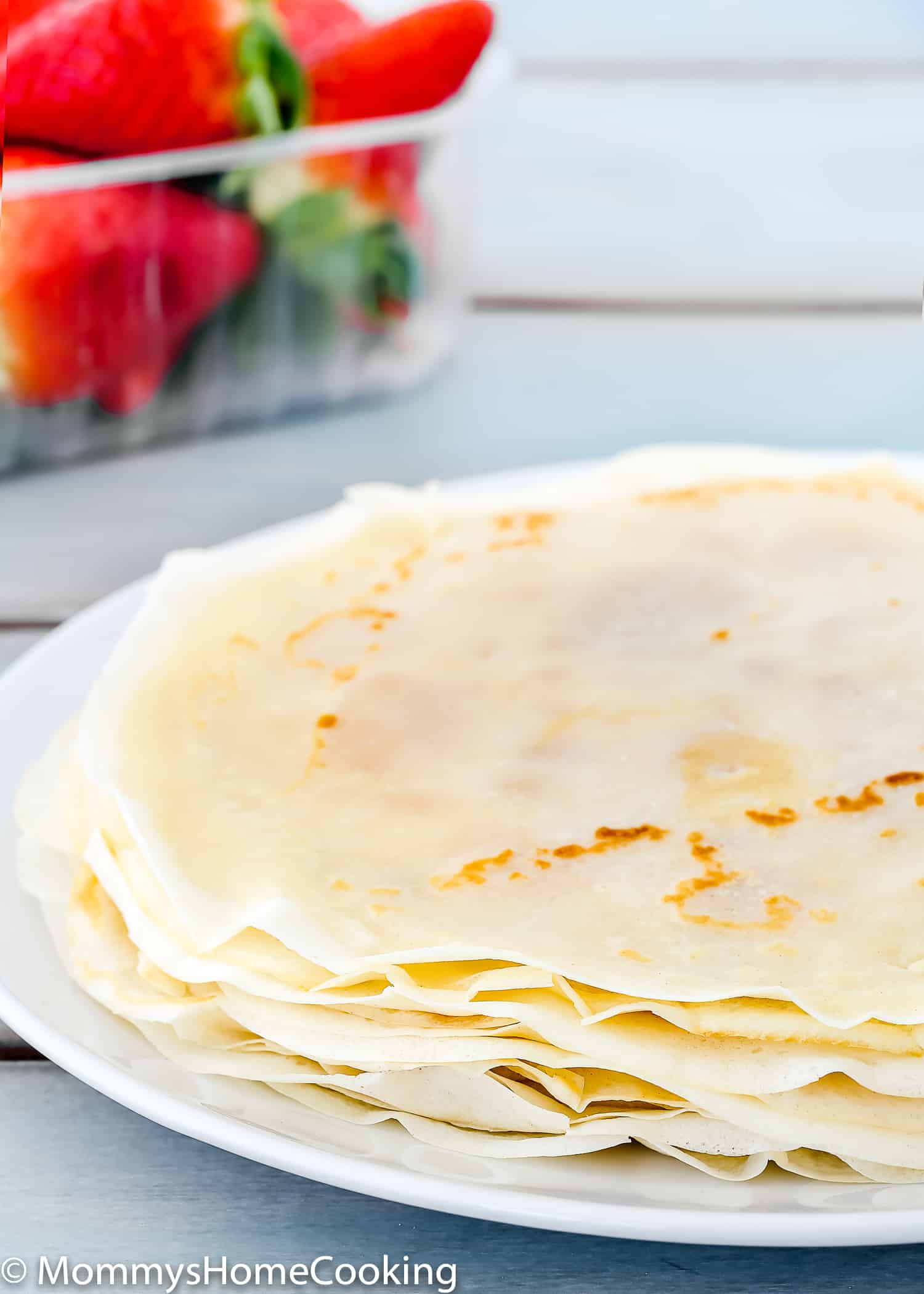 Profile view of a stack of crepes on a plate.
