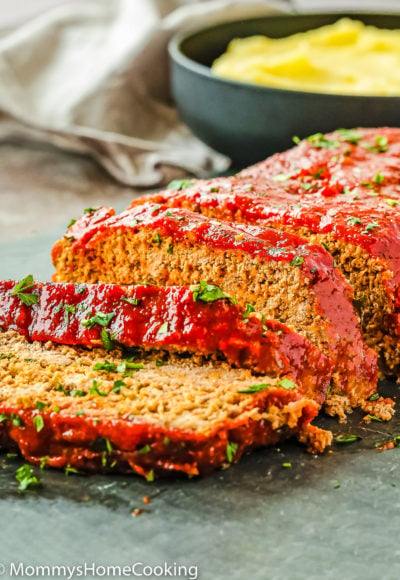 sliced egg-free meatloaf with glaze and garnished with chopped parsley.