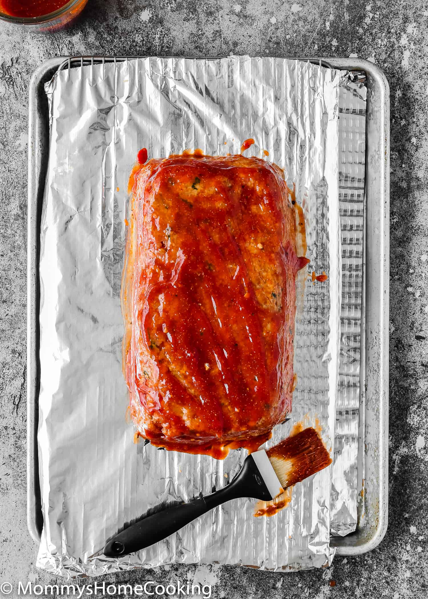  Unbaked Eggless Meatloaf over a baking tray with meatloaf sauce