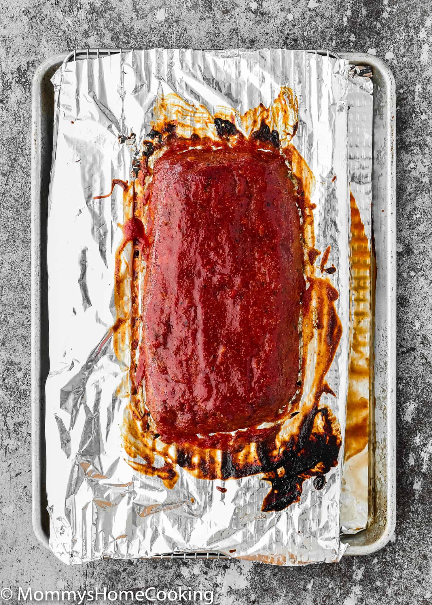 Baked Eggless Meatloaf over a baking tray with meatloaf sauce