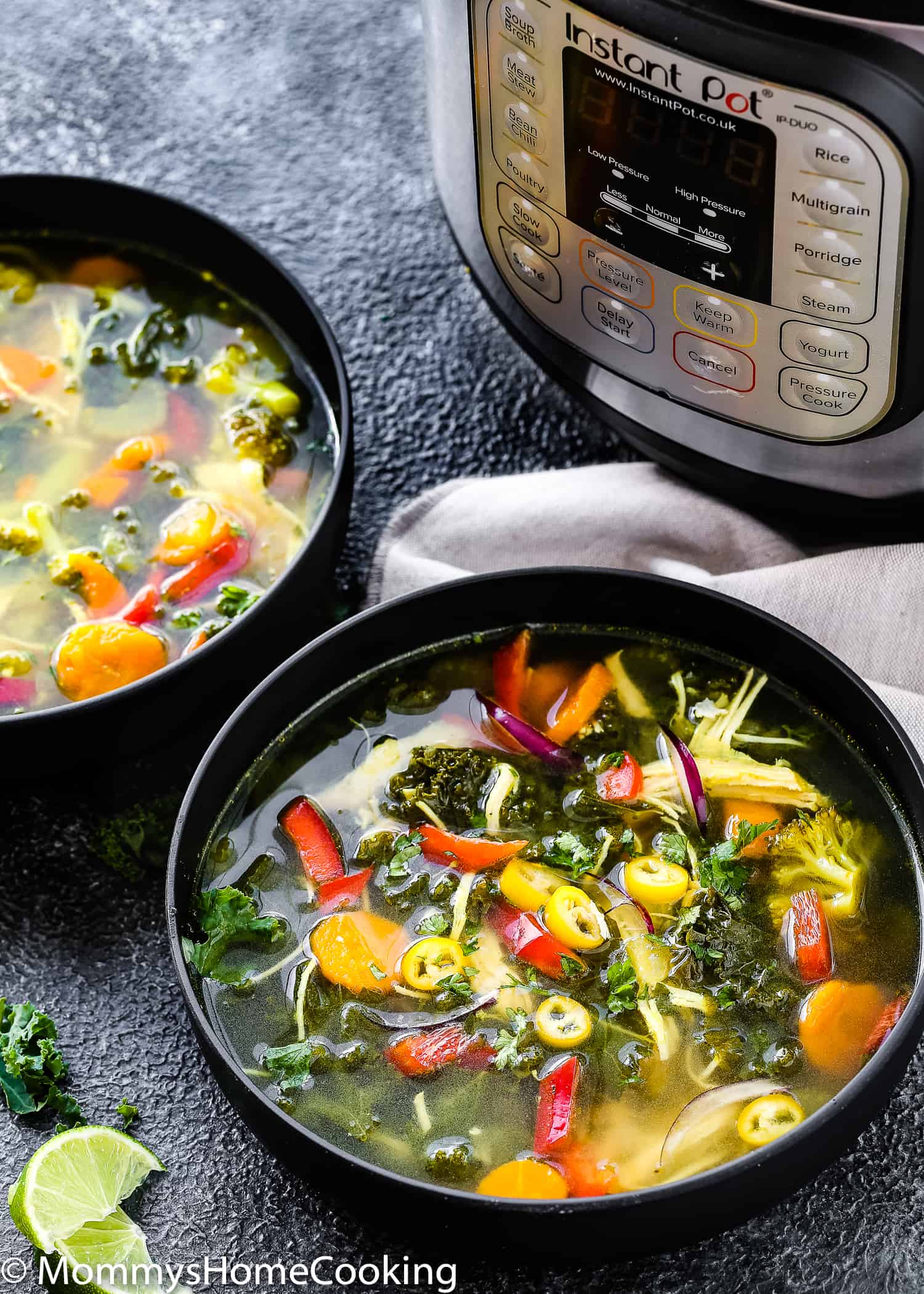 two black bowls with detox soup with a instant pot in the background.
