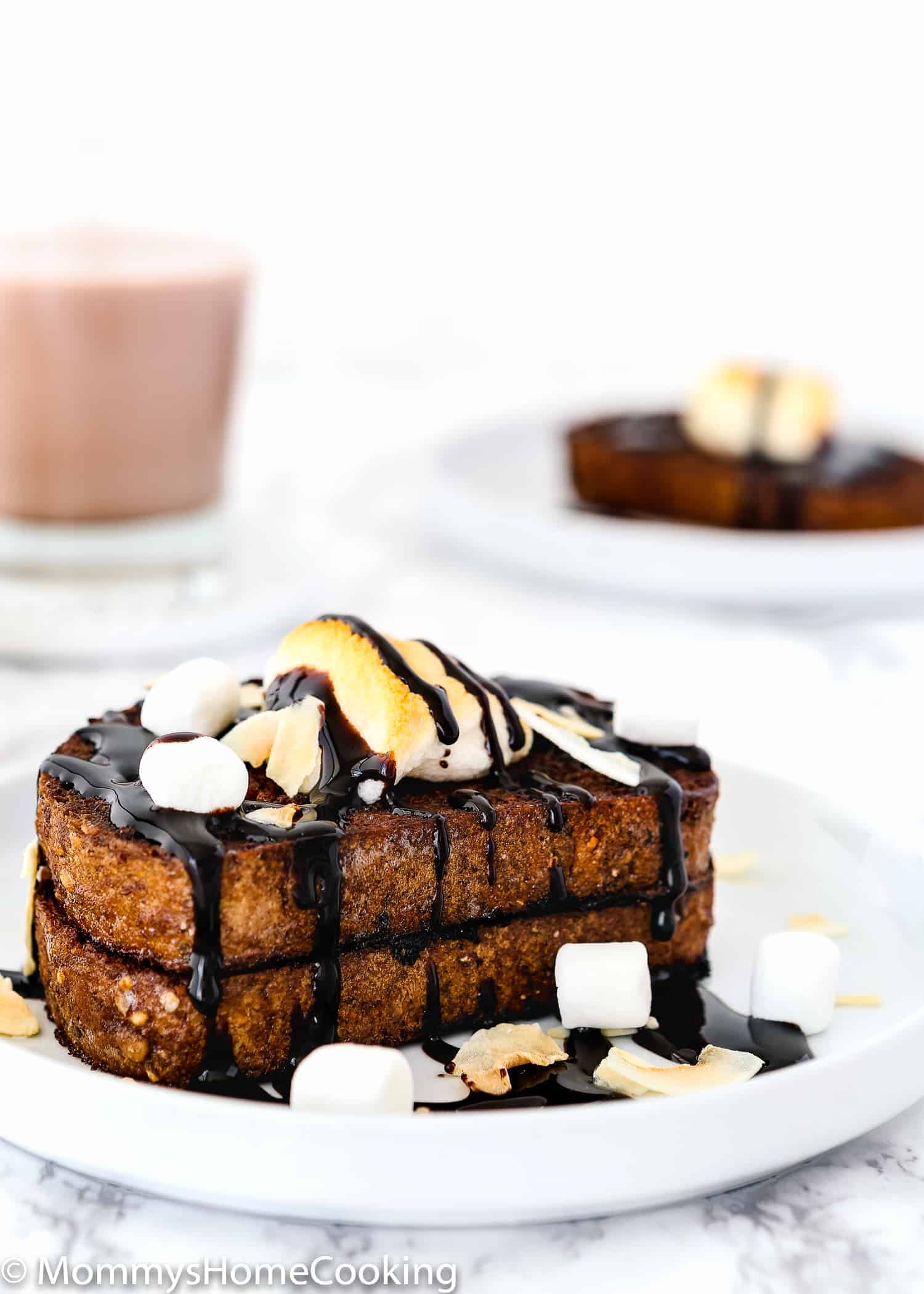 Eggless Chocolate French Toast on a plate with chocolate sauce and marshmallows.