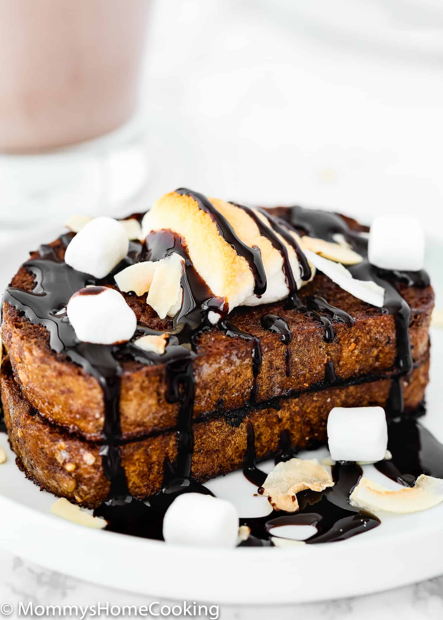 Eggless Chocolate French Toast on a plate with chocolate sauce, coconut  and marshmallows.