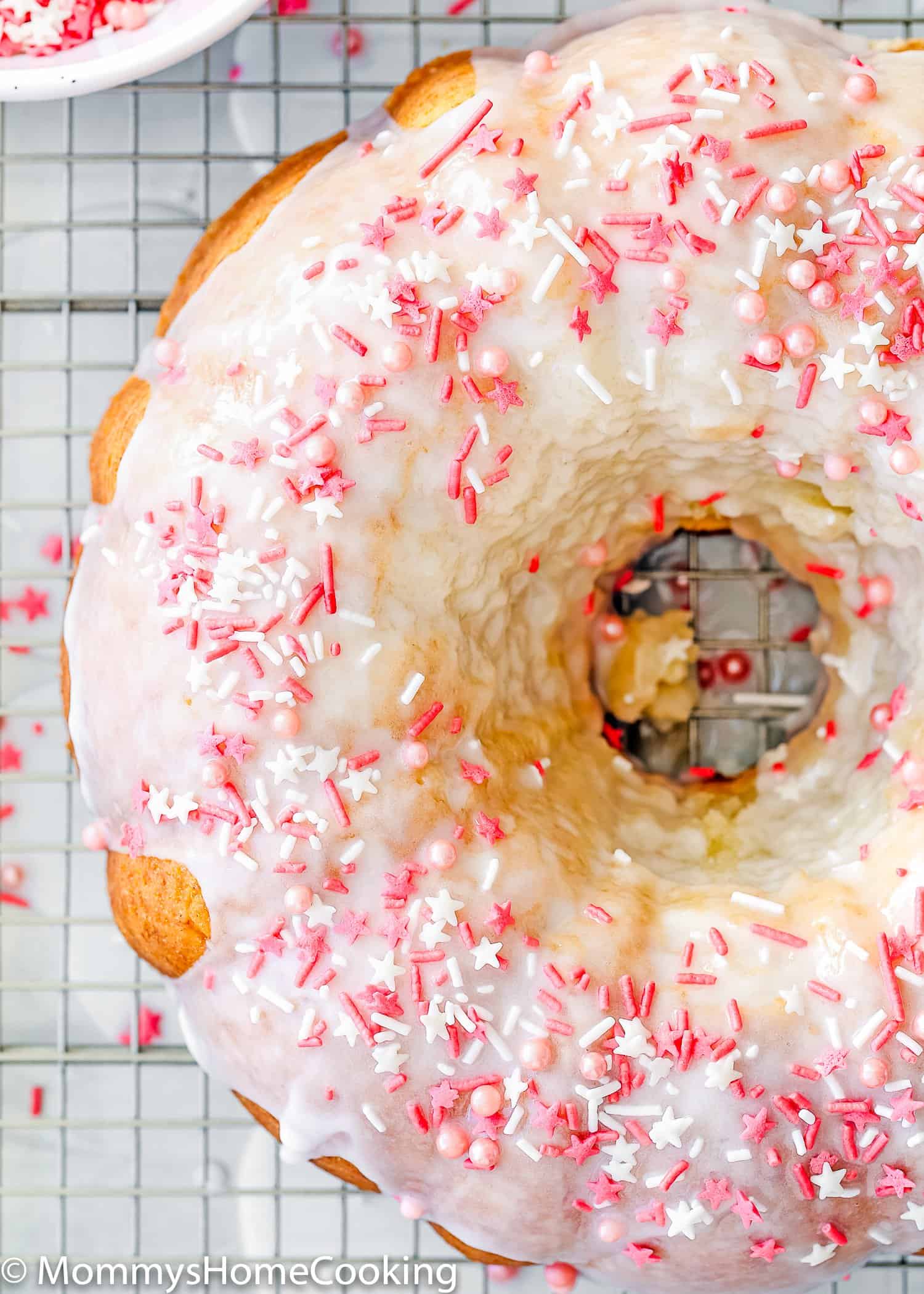Easy Eggless Vanilla Pound Cake drizzle with sugar glaze and sprinkles.