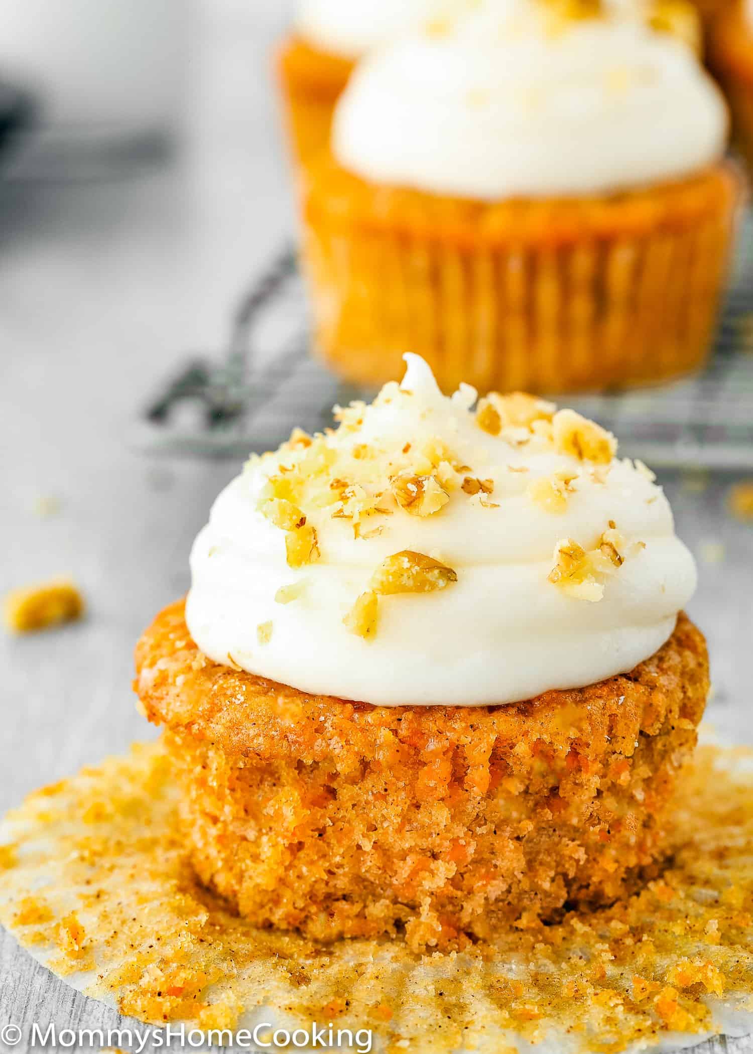 Eggless Carrot Cake Cupcake with cream cheese frosting and chopped walnuts in top. 