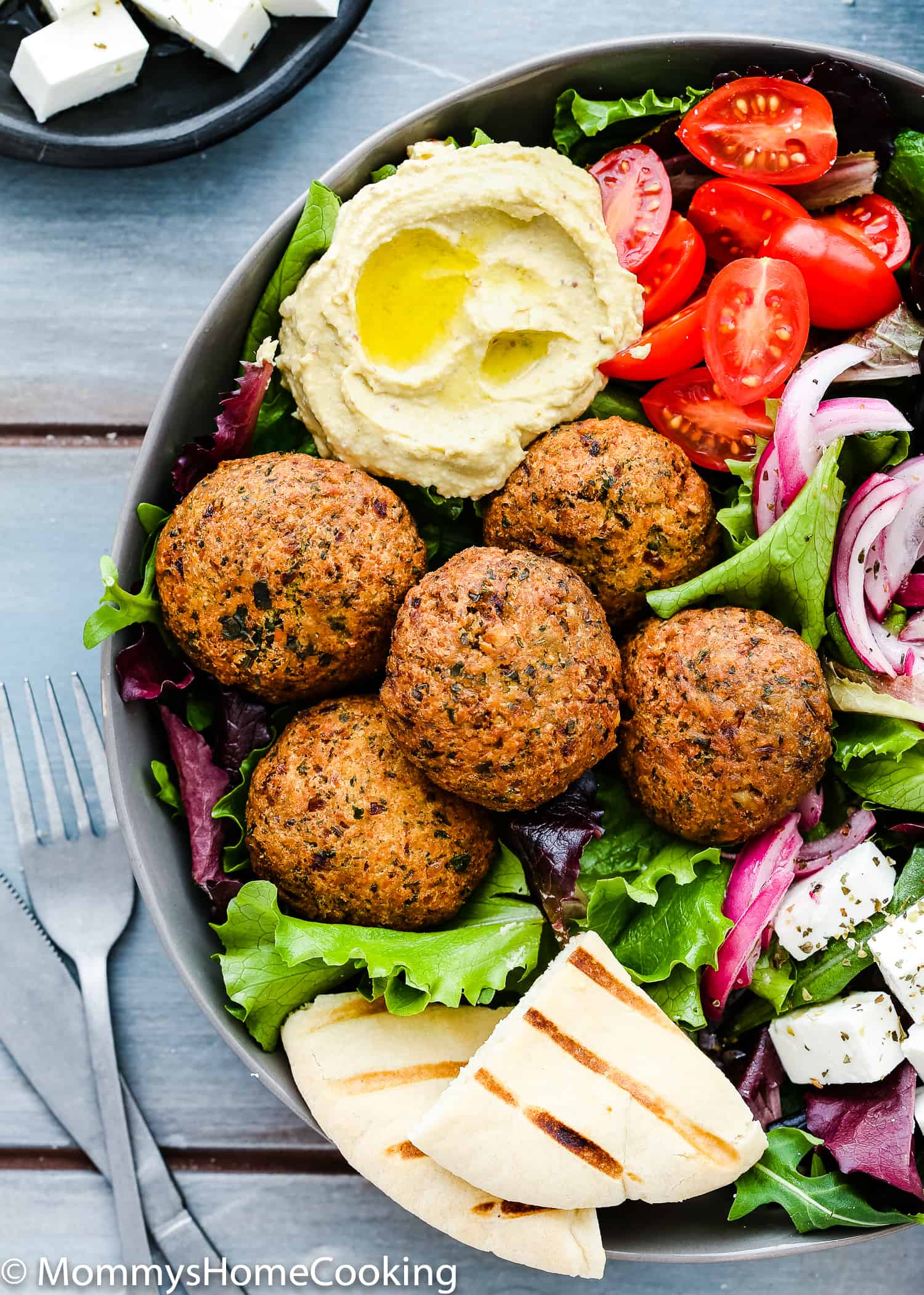 Falafel Salad in a bowl with hummus and pita bread. 