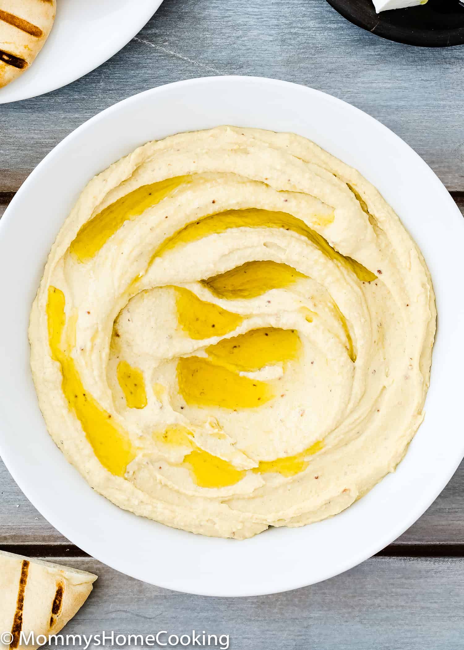homemade mustard hummus in a bowl with olive oil on top.