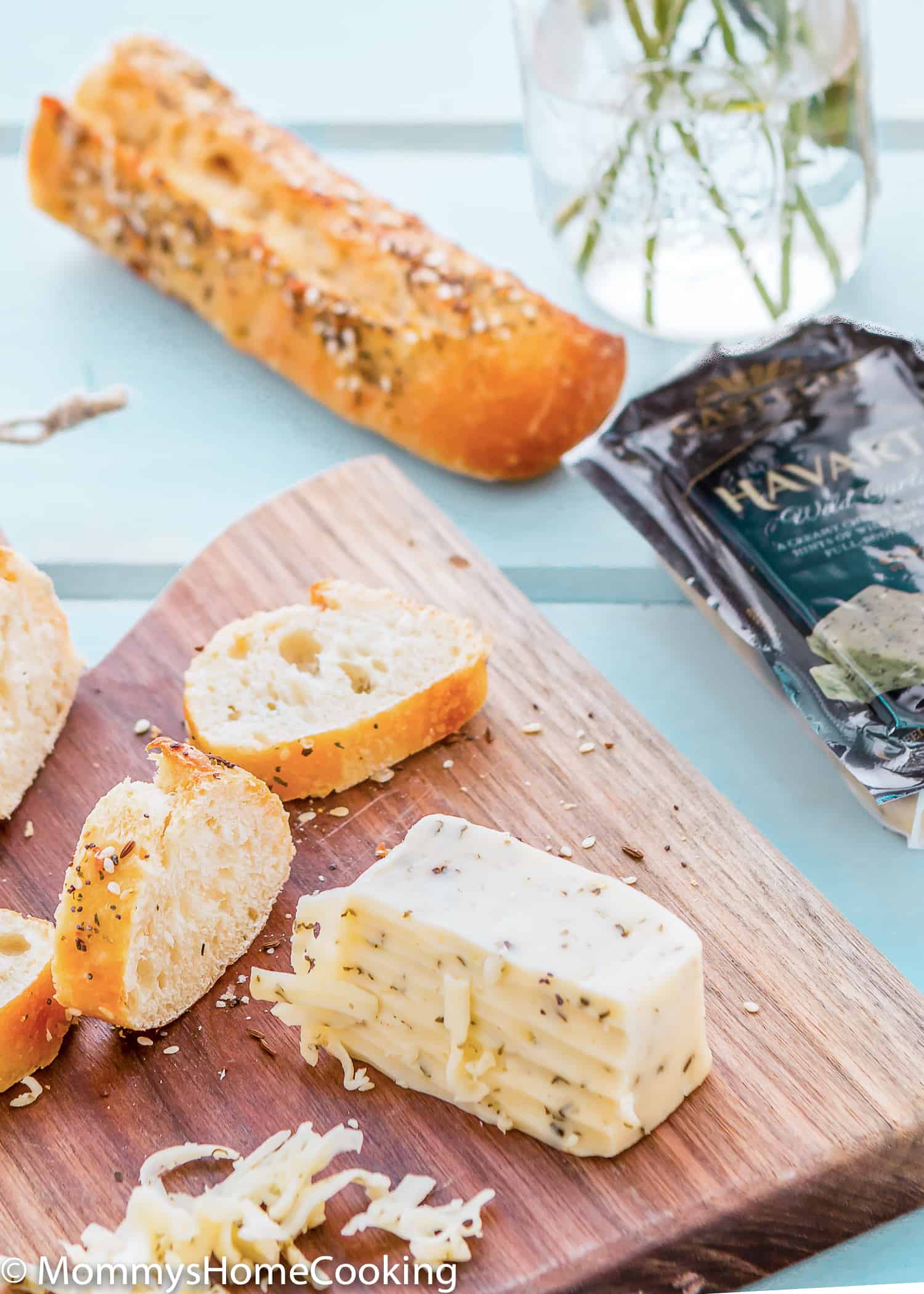 wooden cheeseboard with havarti cheese and bread