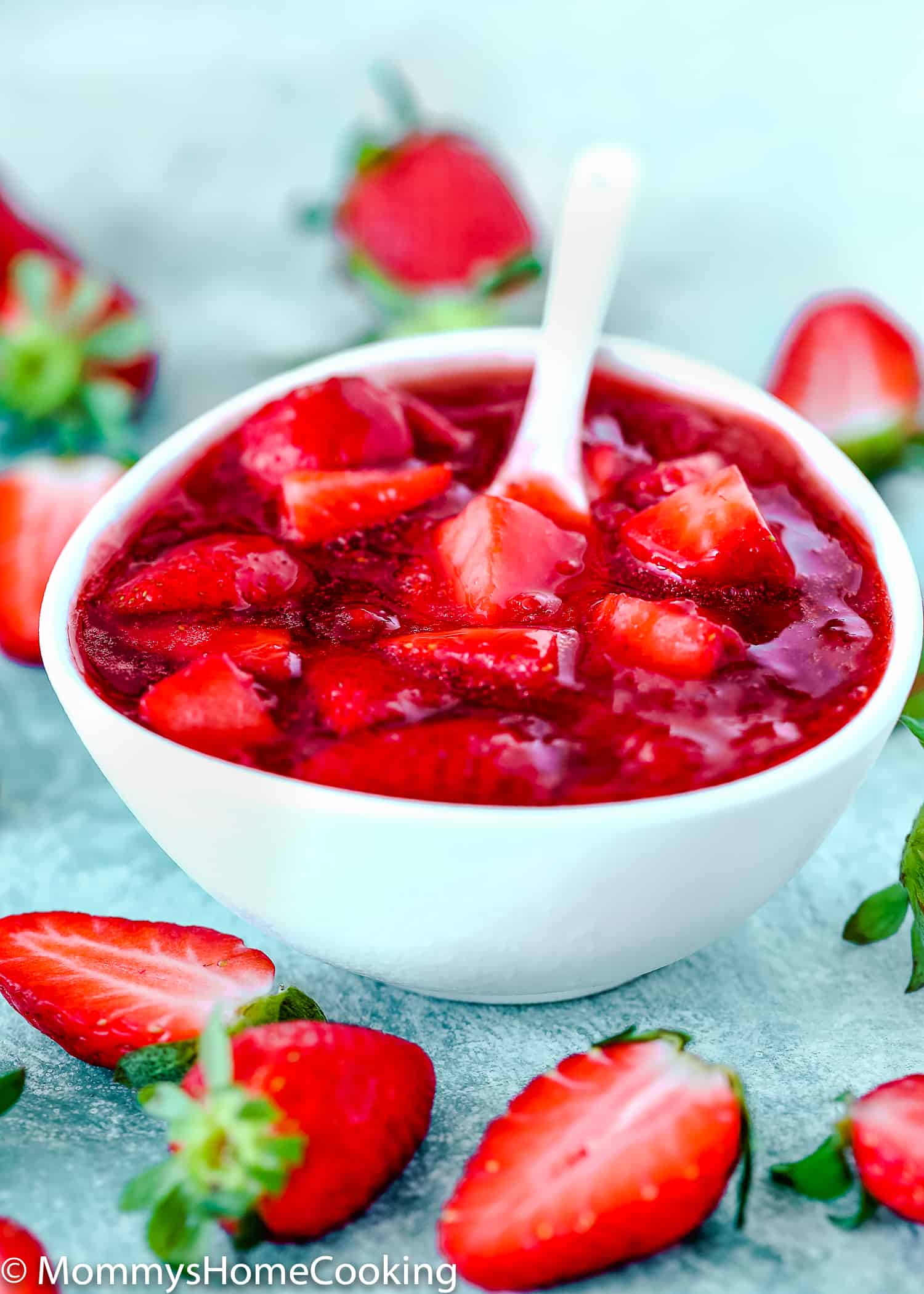 strawberry sauce/topping  in a white bowl and fresh strawberries